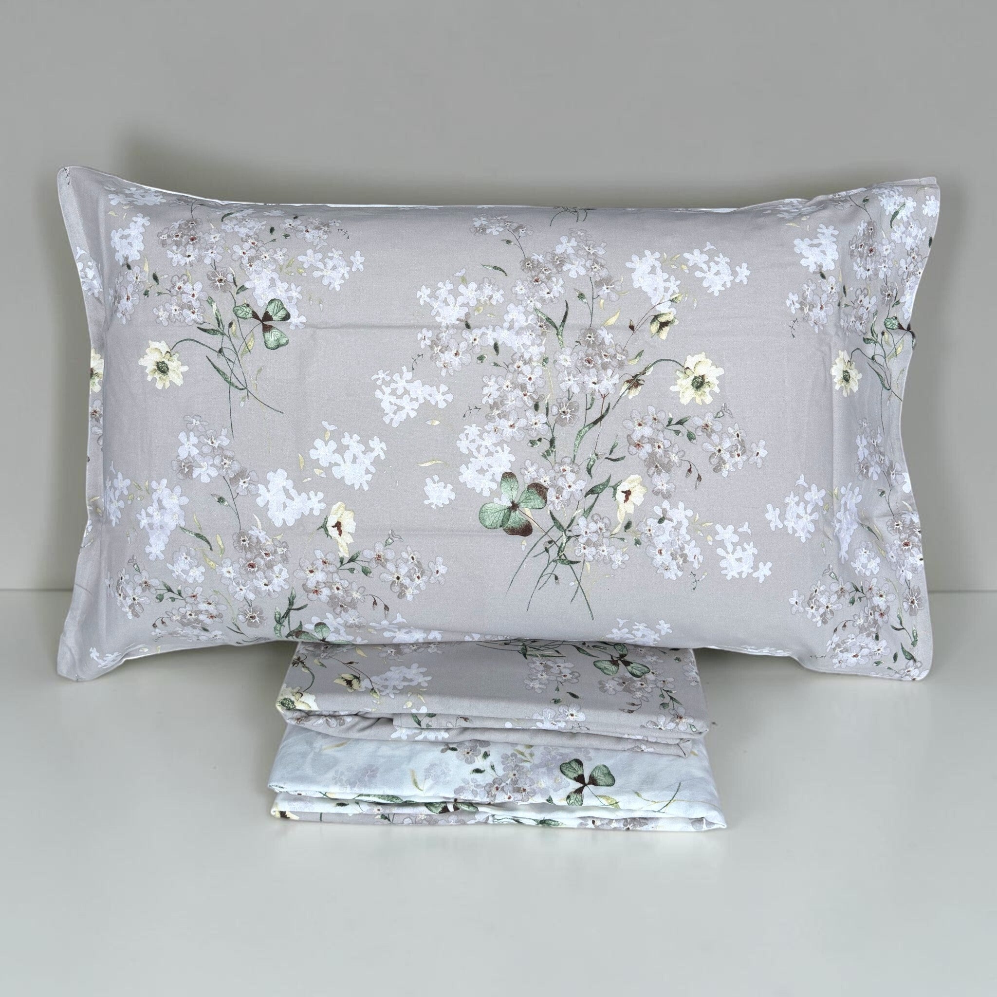 Completo Cogal 2620 Silver Grey ripiegato con federa a piccoli fiori e rametti su fondo grigio argento.