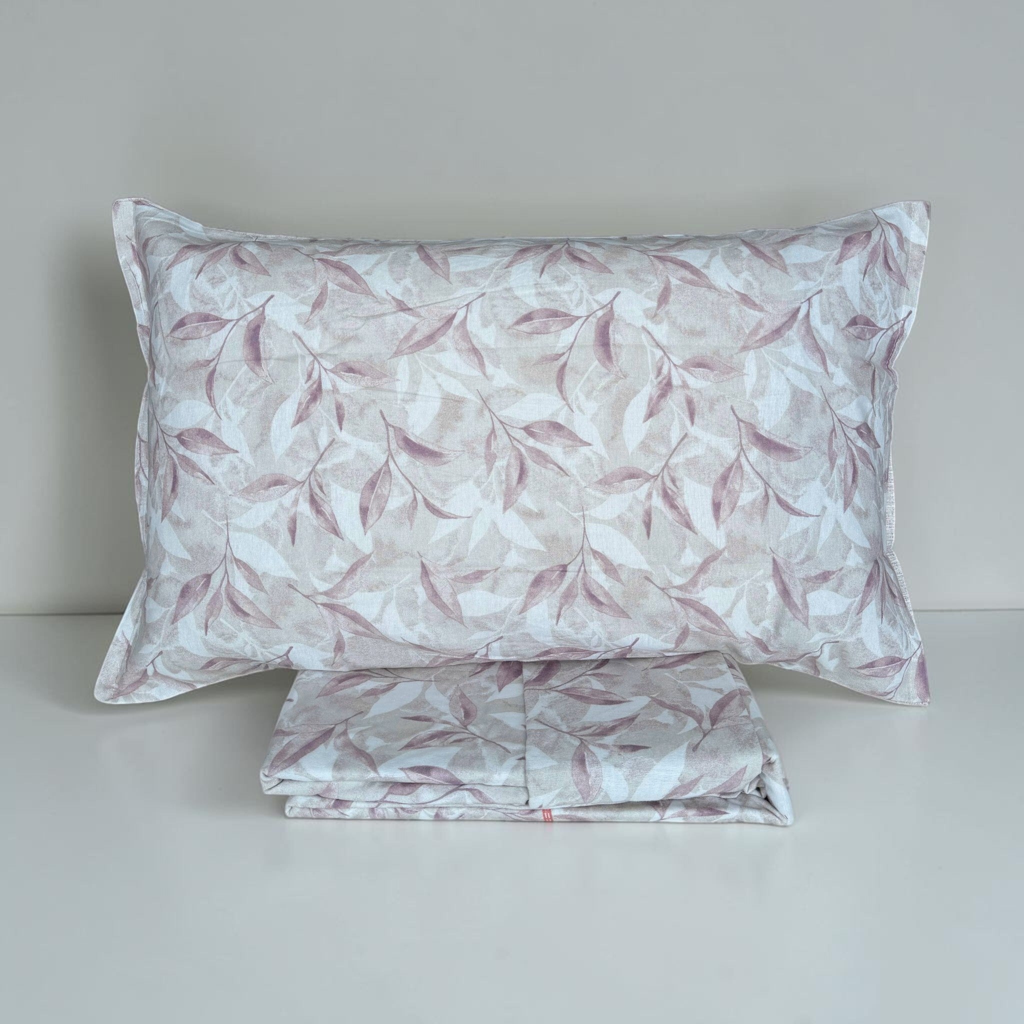 Completo Cogal 2656 Malva ripiegato con federa botanica nei toni rosa e tortora e tessuti coordinati.