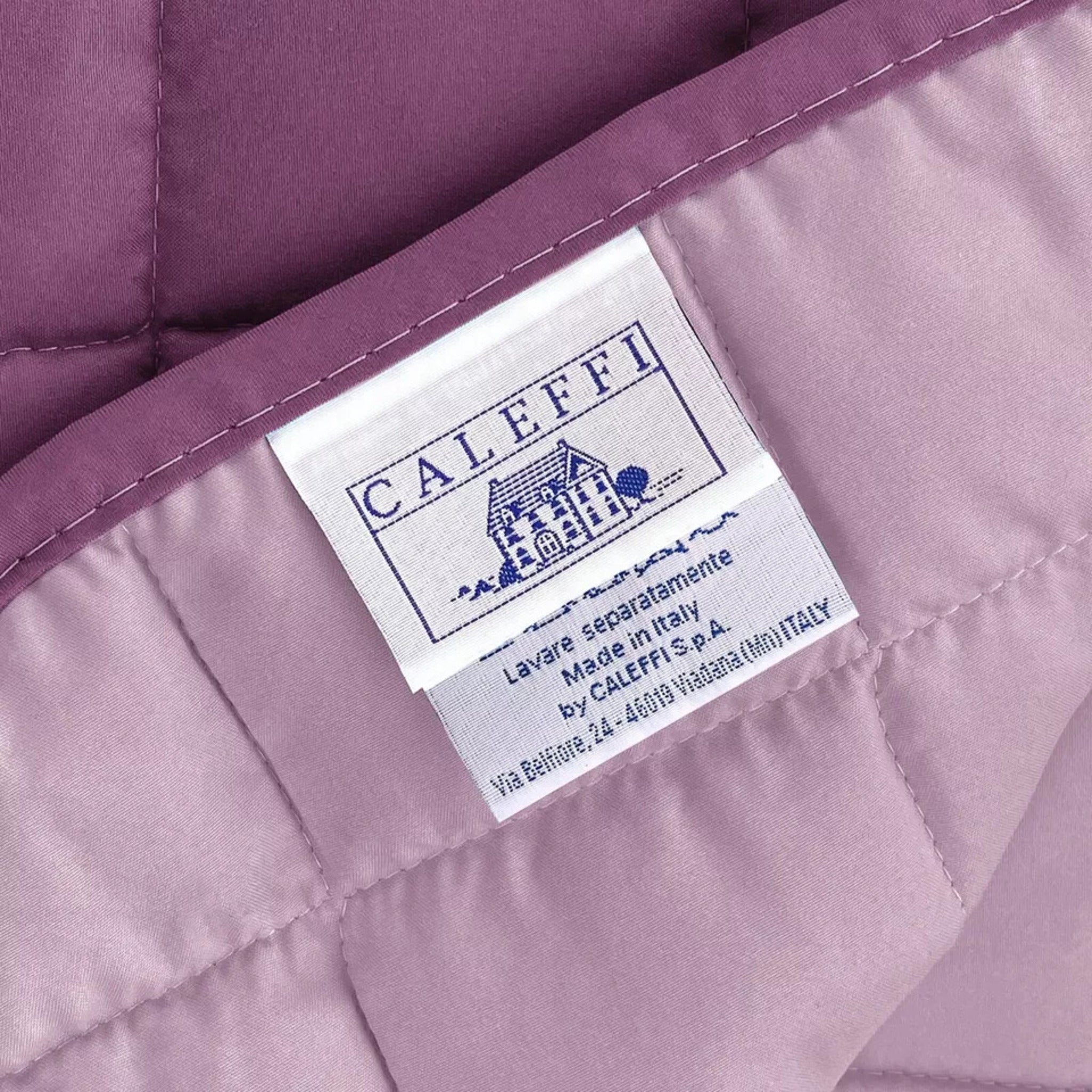 Dettaglio del copriletto Caleffi Modern reversibile ciclamino e lilla con etichetta Caleffi