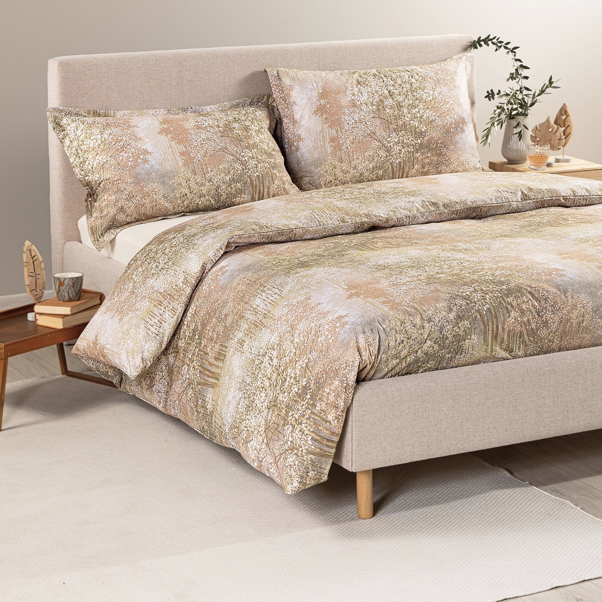 Completo copripiumino matrimoniale Caleffi Bosco su letto imbottito beige, con fantasia boschiva e due federe coordinate.