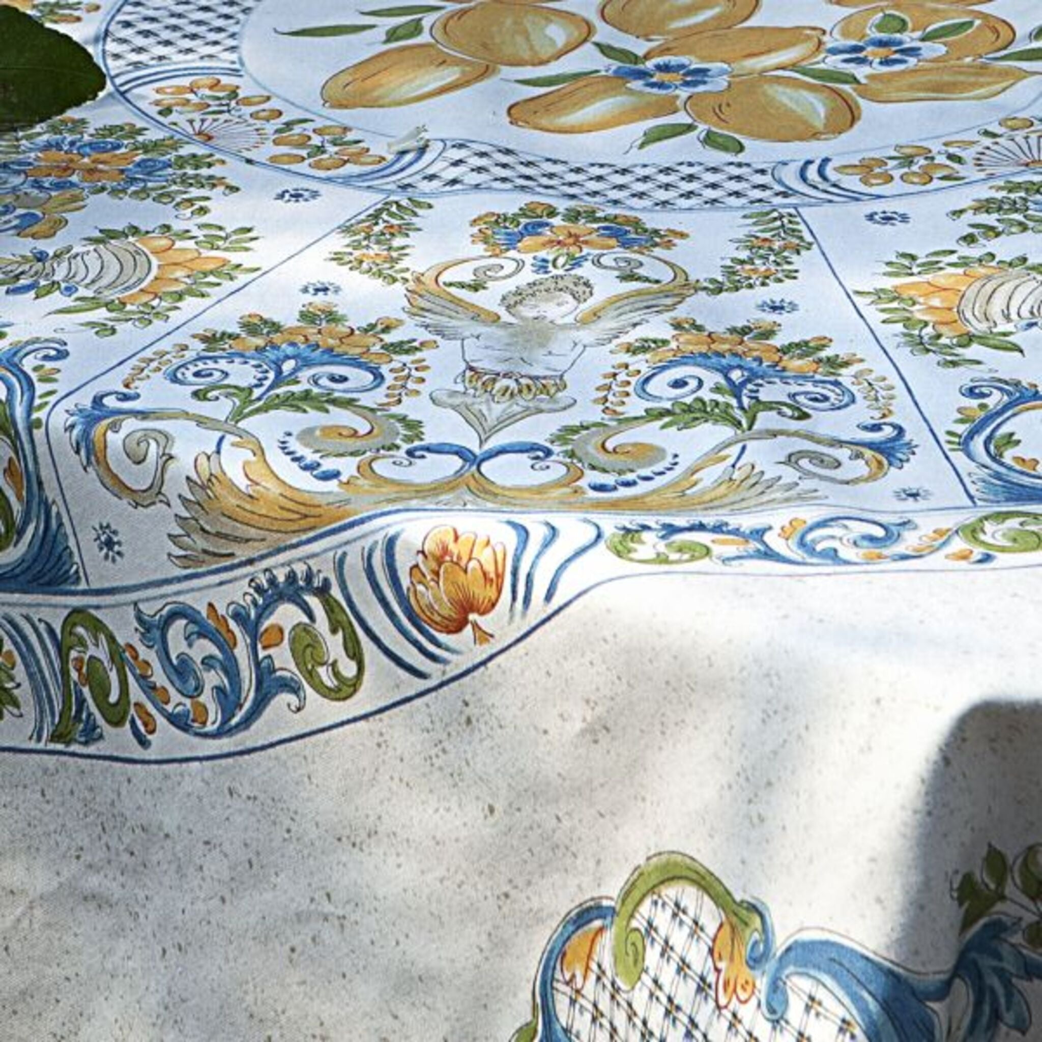 Dettaglio della fantasia Ravello Mirabello con maioliche decorative, limoni e motivi floreali su cotone biologico.