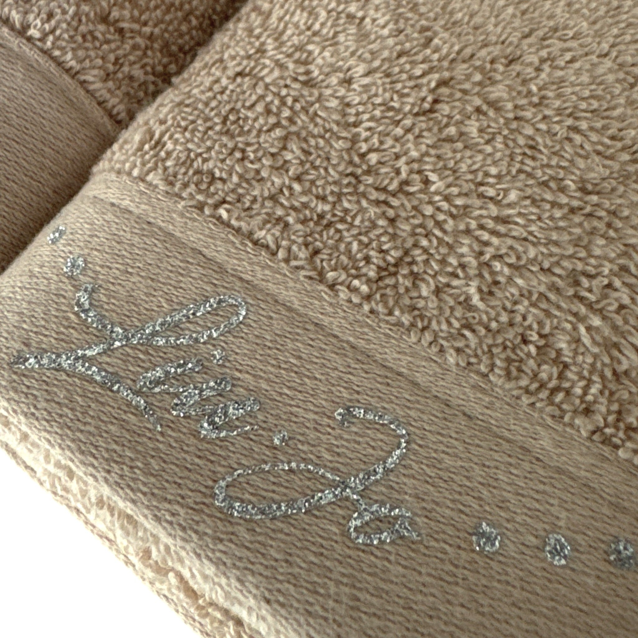 Dettaglio della spugna 100% cotone e del logo Liu Jo in lurex argento sull’asciugamano Happy sabbia