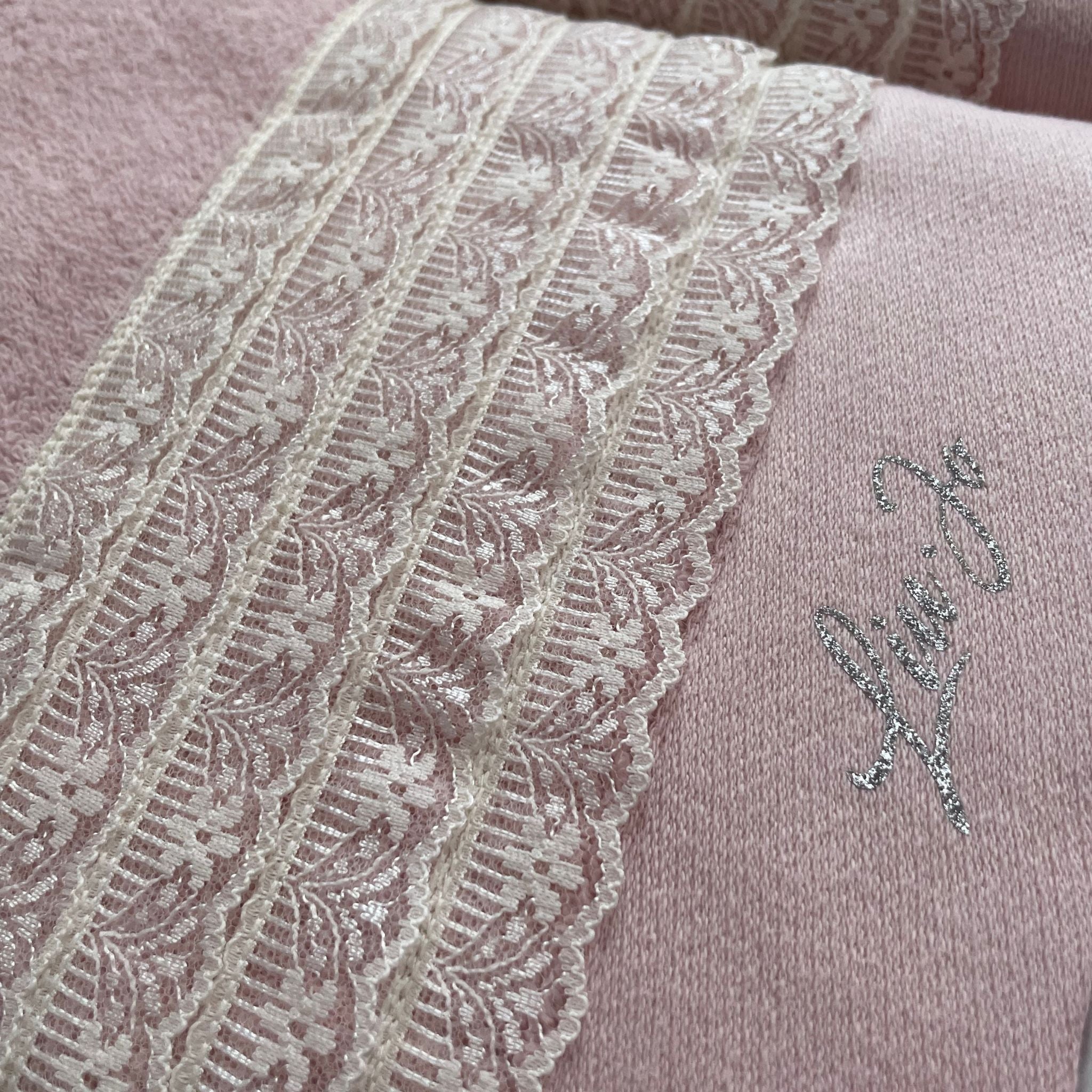 Dettaglio della fascia in pizzo e del logo Liu Jo in lurex sull’asciugamano viso Paradiso Rosy