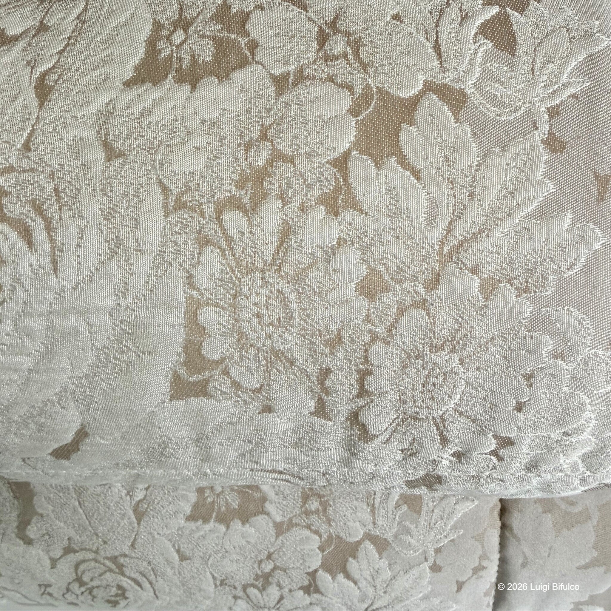 Dettaglio ravvicinato del tessuto floreale in raso jacquard della trapunta Caleffi Gloria colore Biscotto
