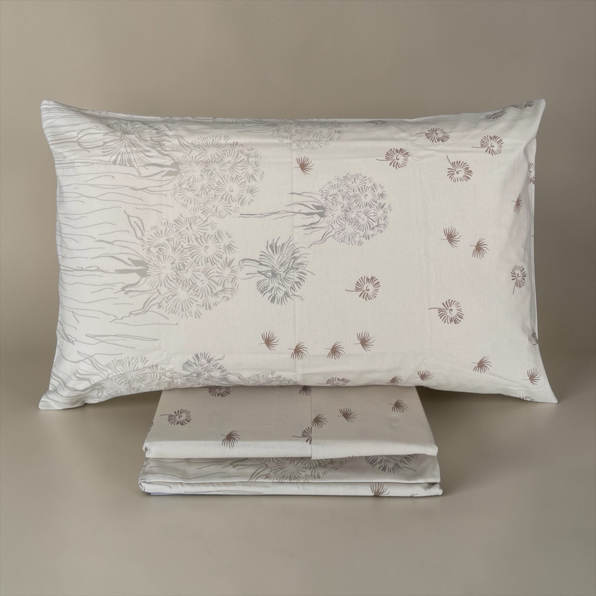 Federa Caleffi Country Chic 2 con grandi soffioni tortora e piccoli motivi sparsi, accanto alle lenzuola ripiegate.