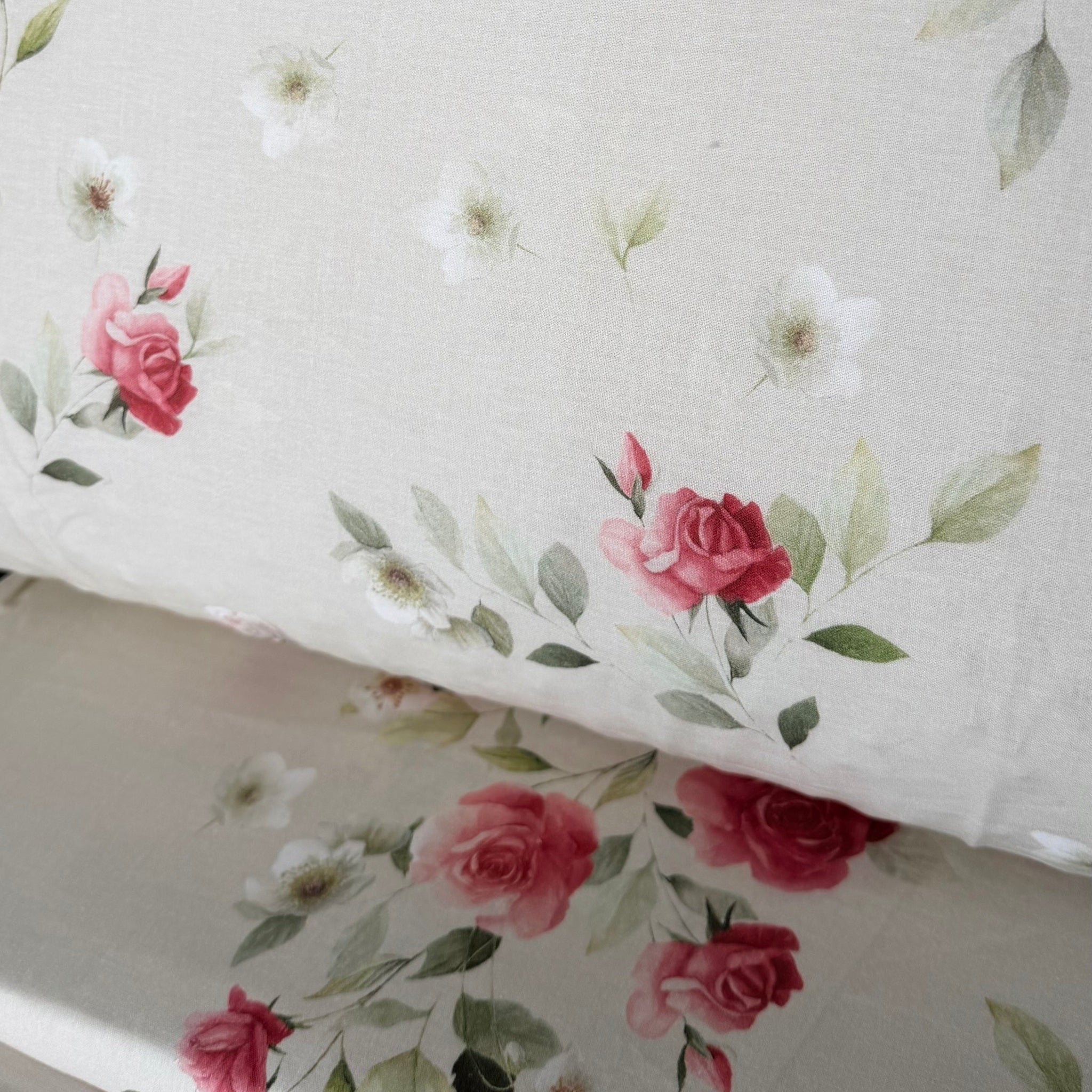 Dettaglio della stampa digitale Caleffi Rosier con rose sfumate rosa, piccoli fiori bianchi e foglie verdi su fondo chiaro