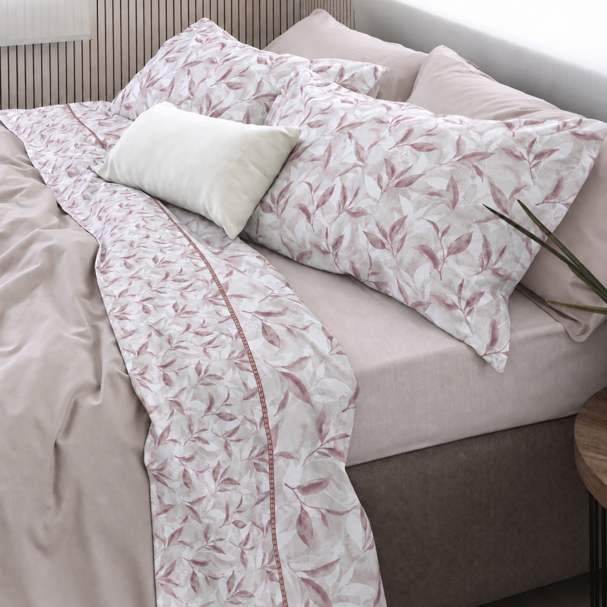 Letto matrimoniale con lenzuola Cogal 2656 Malva, fantasia di foglie rosa polveroso e risvolto con disegno in scala ridotta.