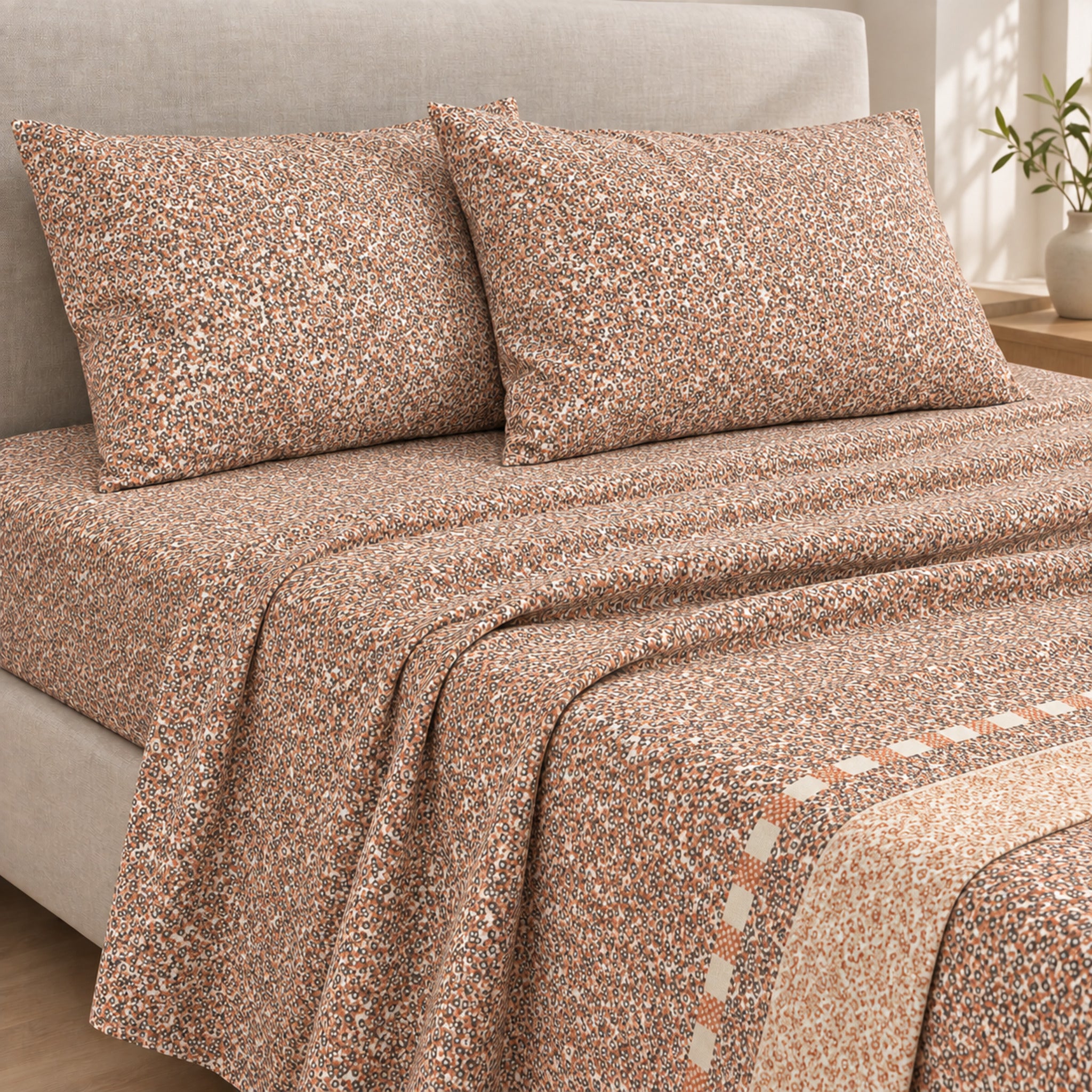 Lenzuola matrimoniali Caleffi Botanical Naturale sul letto, con piccoli fiori nei toni terracotta e marrone su fondo chiaro
