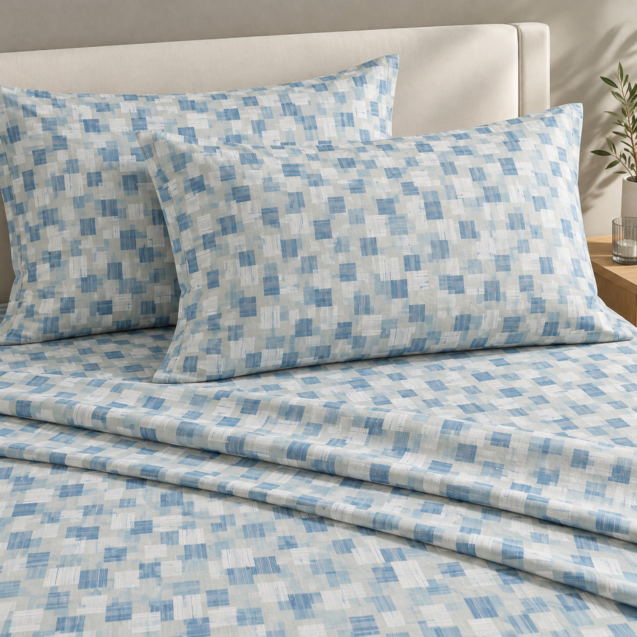 Lenzuola matrimoniali Caleffi Kilt Bluette sul letto, con fantasia geometrica azzurra e blu e due federe coordinate