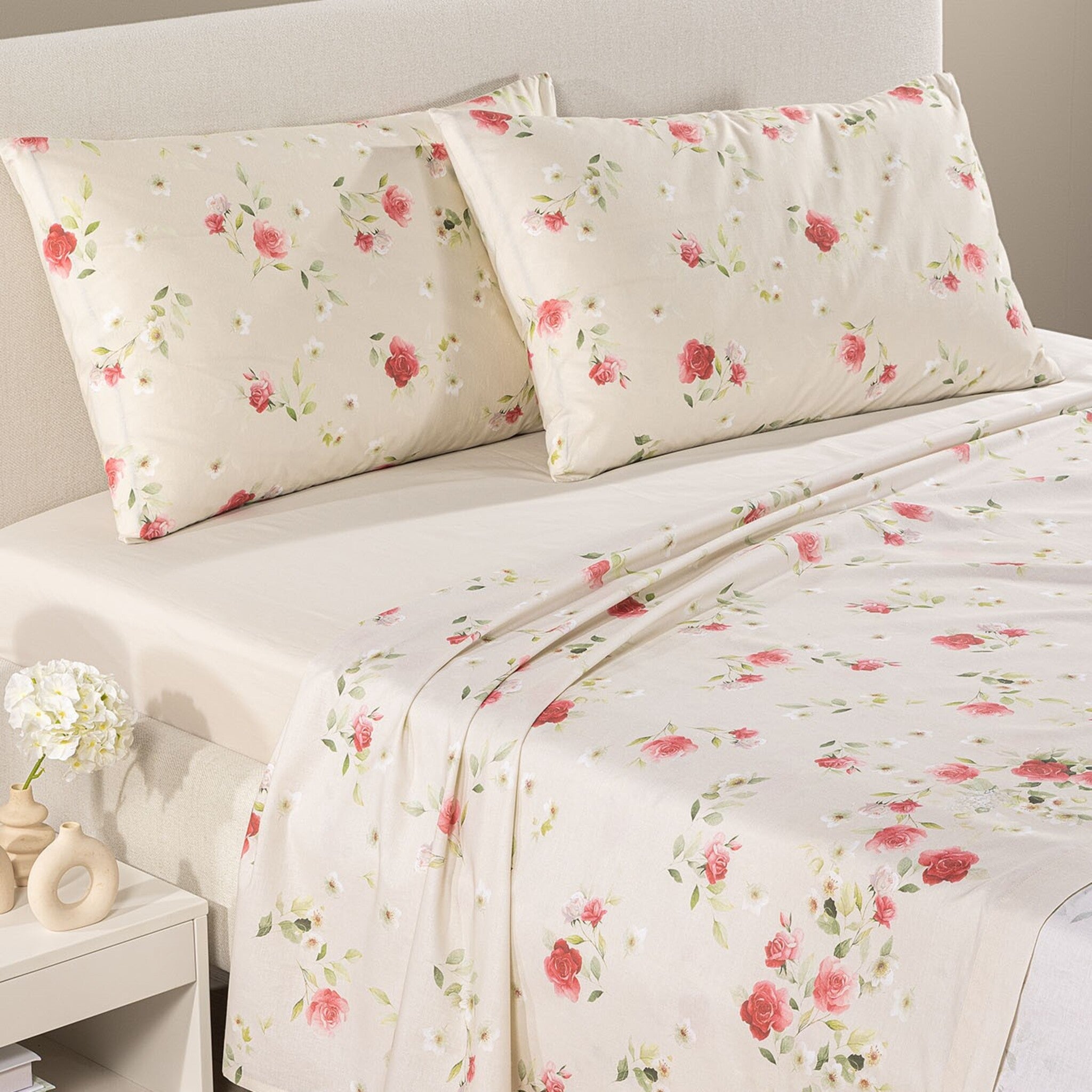 Lenzuola matrimoniali Caleffi Rosier sul letto, con rose rosa e rosse, federe floreali e lenzuolo sotto in tinta unita