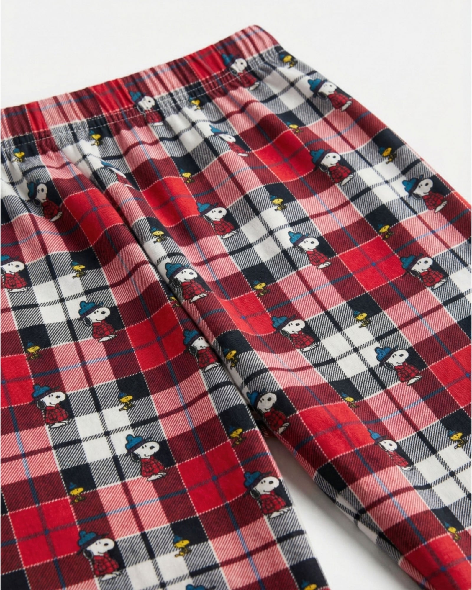 Dettaglio pantaloni tartan del pigiama bambino Peanuts con Snoopy e Woodstock