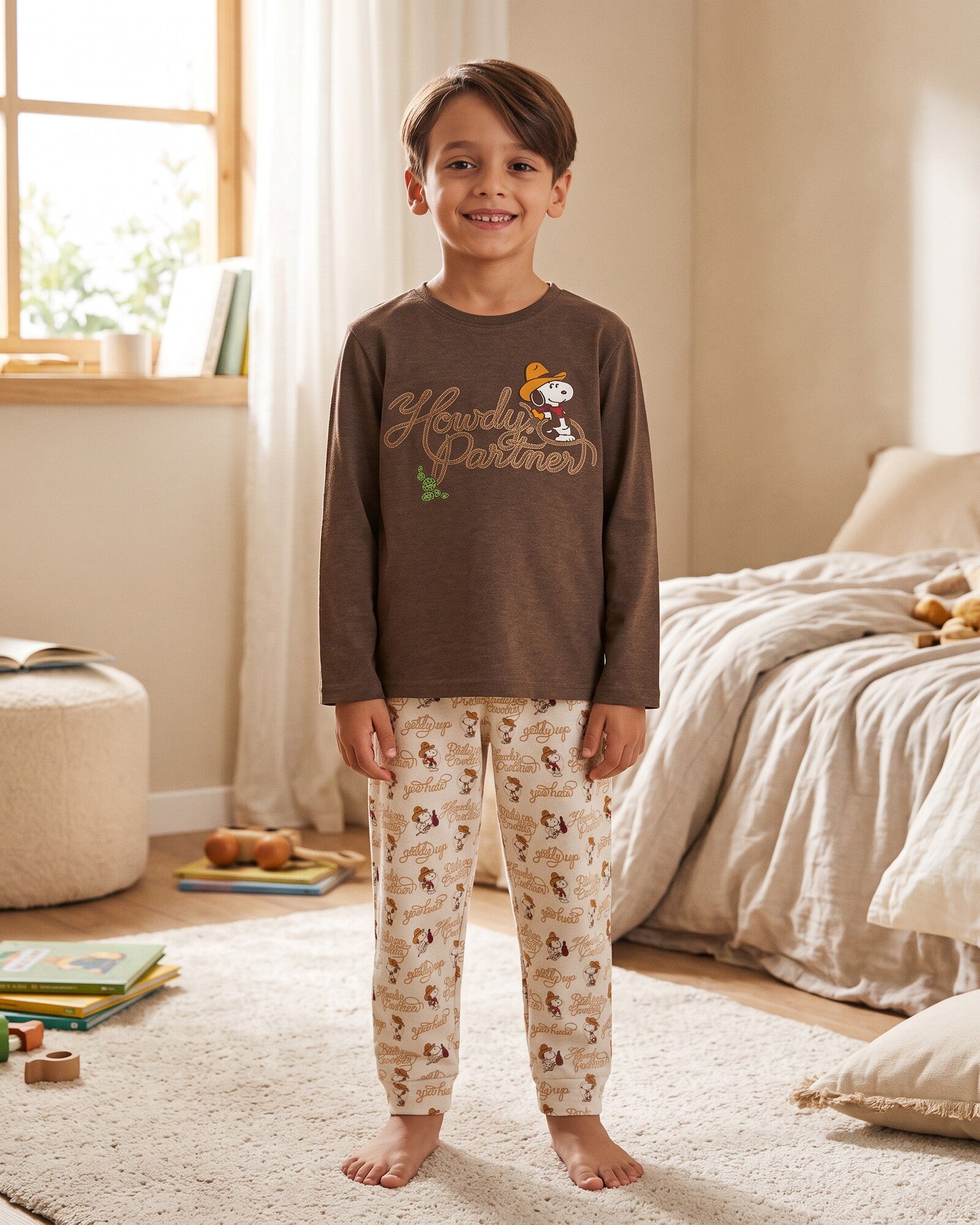 Pigiama bambino Peanuts Country Club 64036 indossato, con maglia cioccolato Snoopy cowboy e pantaloni chiari stampati.
