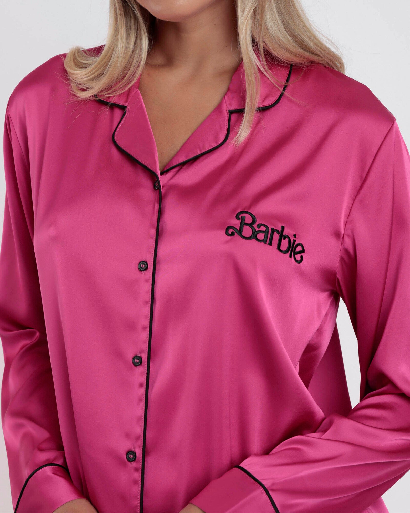 Dettaglio camicia pigiama Barbie in raso fucsia con logo ricamato nero