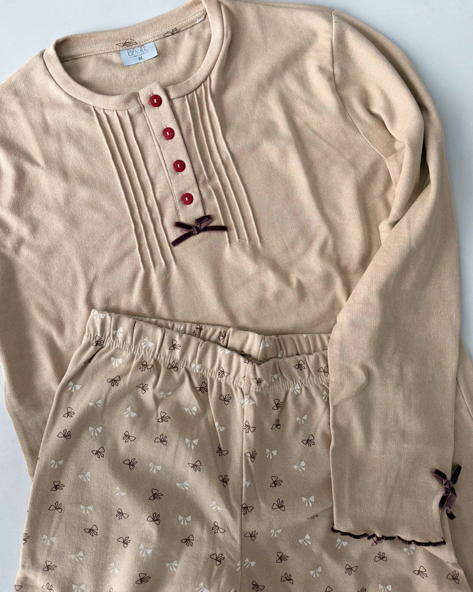 Dettaglio del pigiama beige Basile Milano 3130 con fiocco sullo scollo, fiocchetto sulla manica e pantaloni fantasia