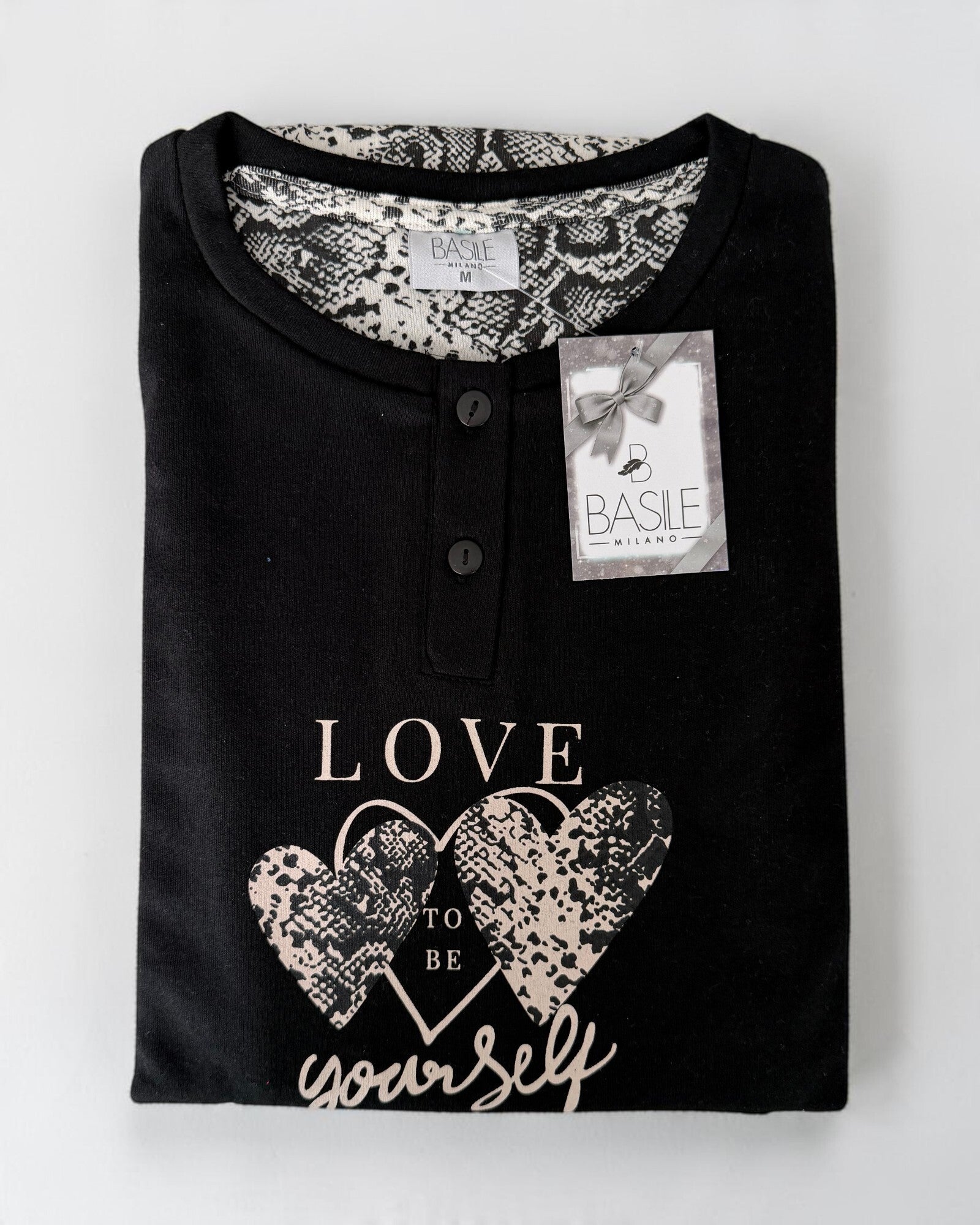 Maglia nera del pigiama Basile Milano 4230 piegata, con due bottoni e stampa di cuori con scritta Love to be yourself