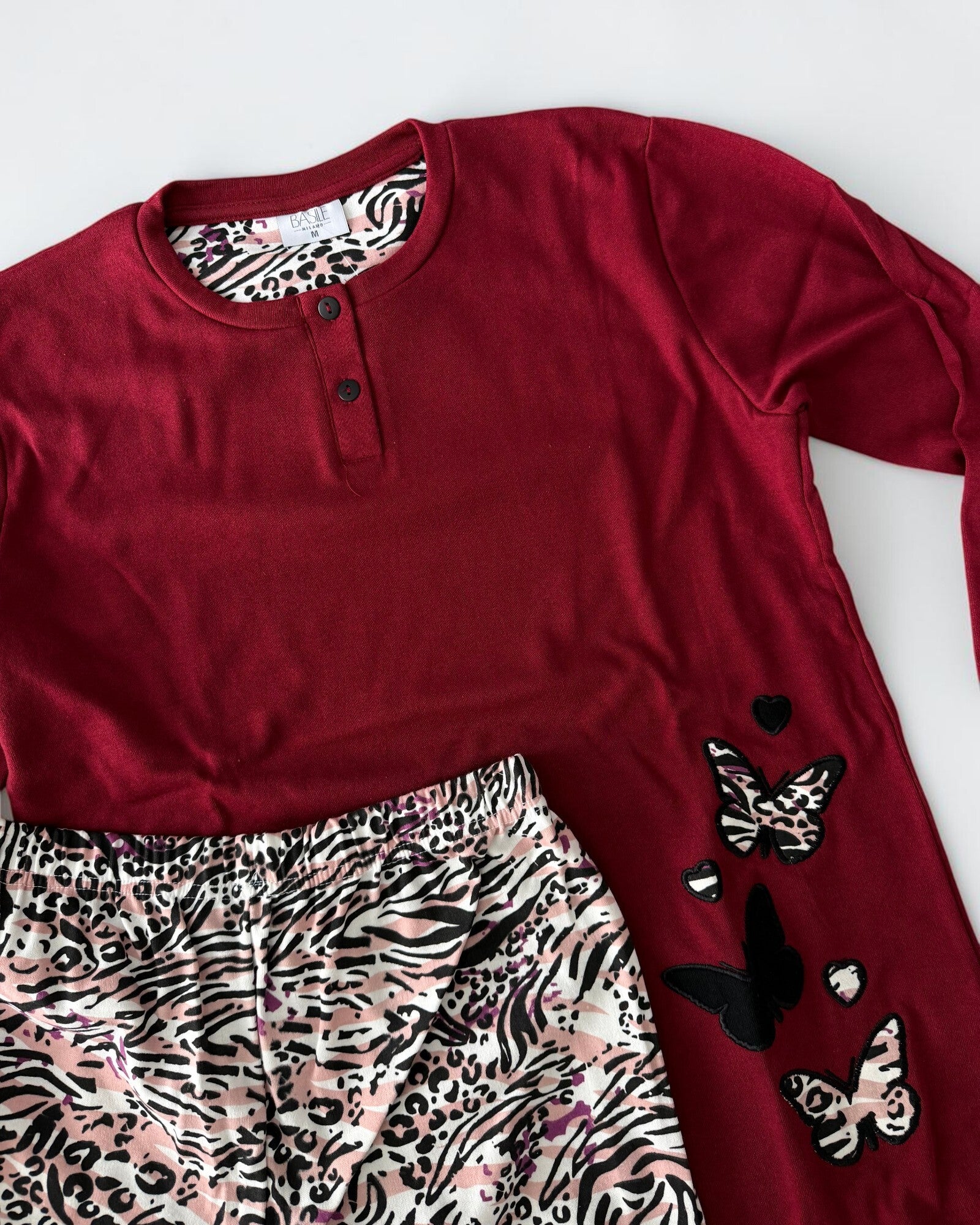Dettaglio del pigiama Basile Milano 3930 Bordeaux con farfalle ricamate e animalier, cuori e vita elasticizzata dei pantaloni.