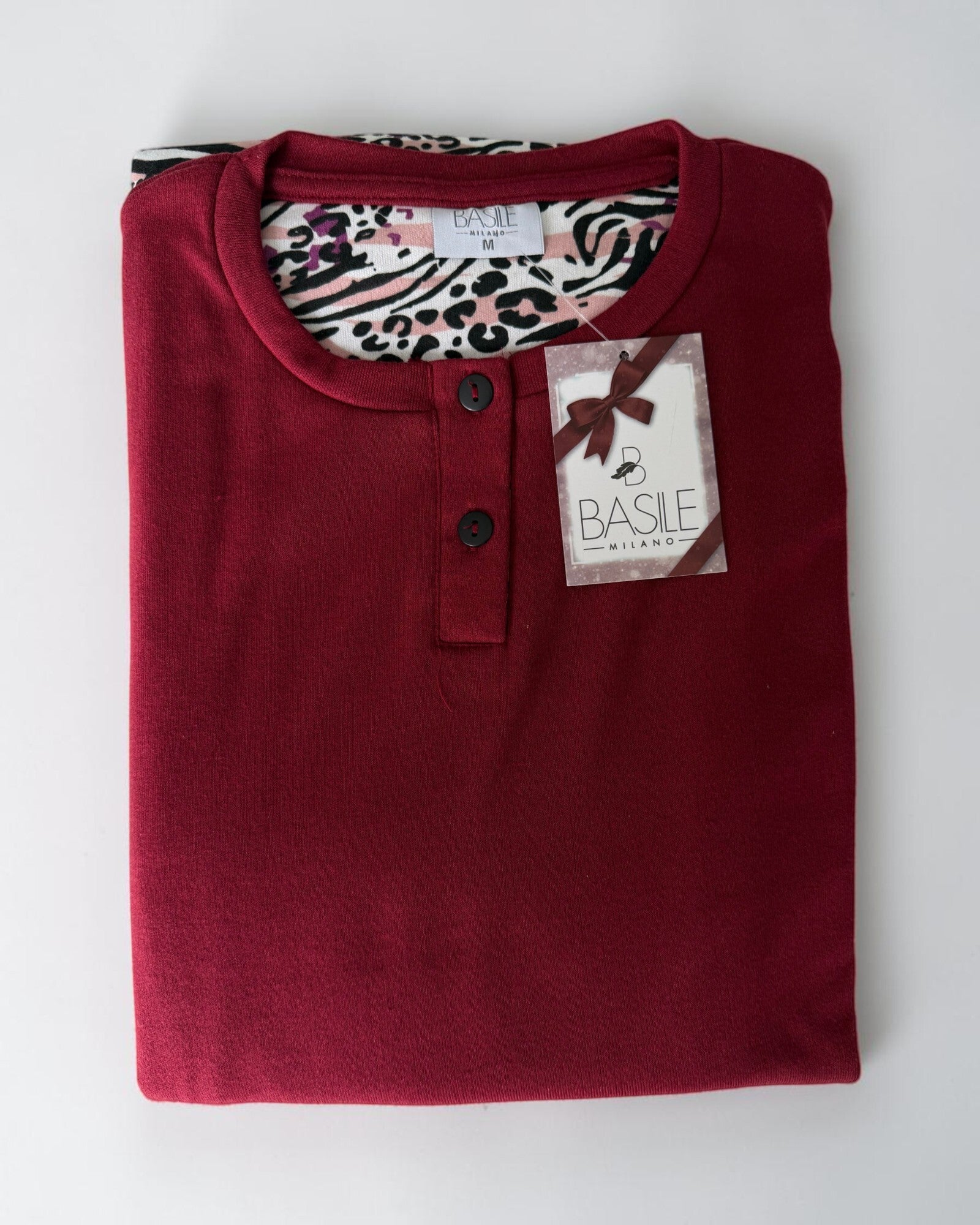 Maglia bordeaux del pigiama Basile Milano 3930 piegata, con due bottoni neri al collo ed etichetta Basile Milano.