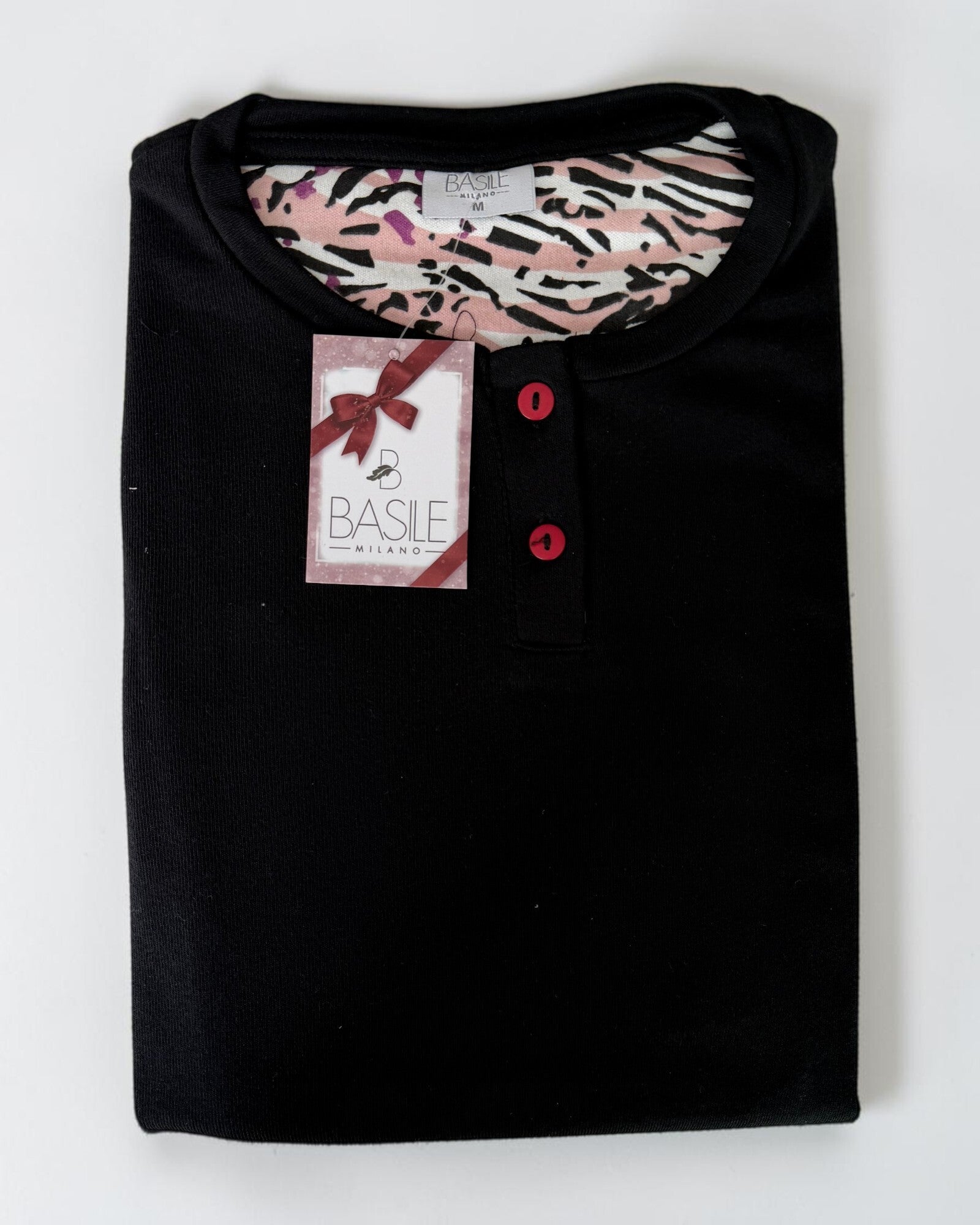 Maglia nera del pigiama Basile Milano 3930 piegata, con scollo serafino, due bottoni a contrasto e cartellino del marchio.