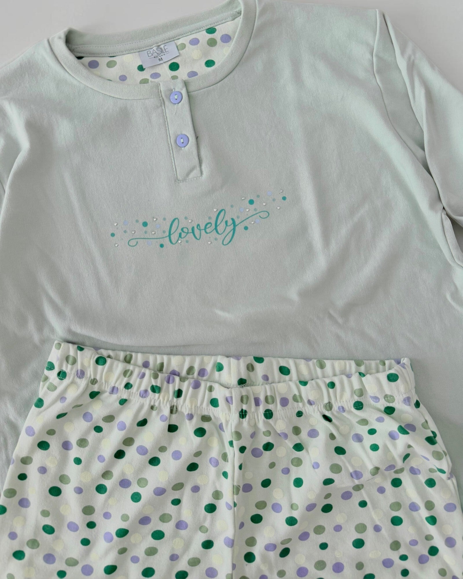 Dettaglio del pigiama Basile Milano 4030 Menta con stampa Lovely e pantaloni con elastico in vita e pois verdi e lilla.