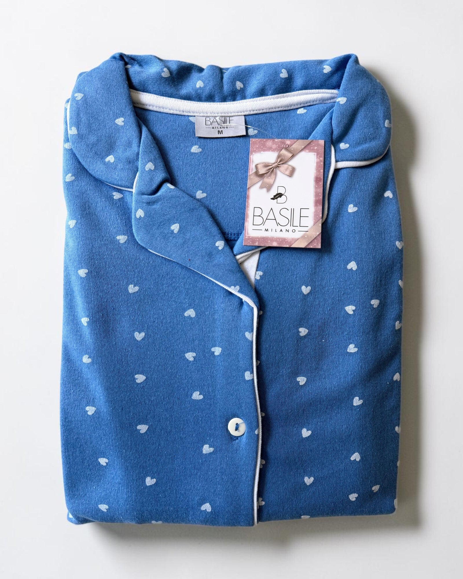 Maglia del pigiama Basile Milano 4531 celeste piegata, con collo rever, profili bianchi e stampa a cuoricini.