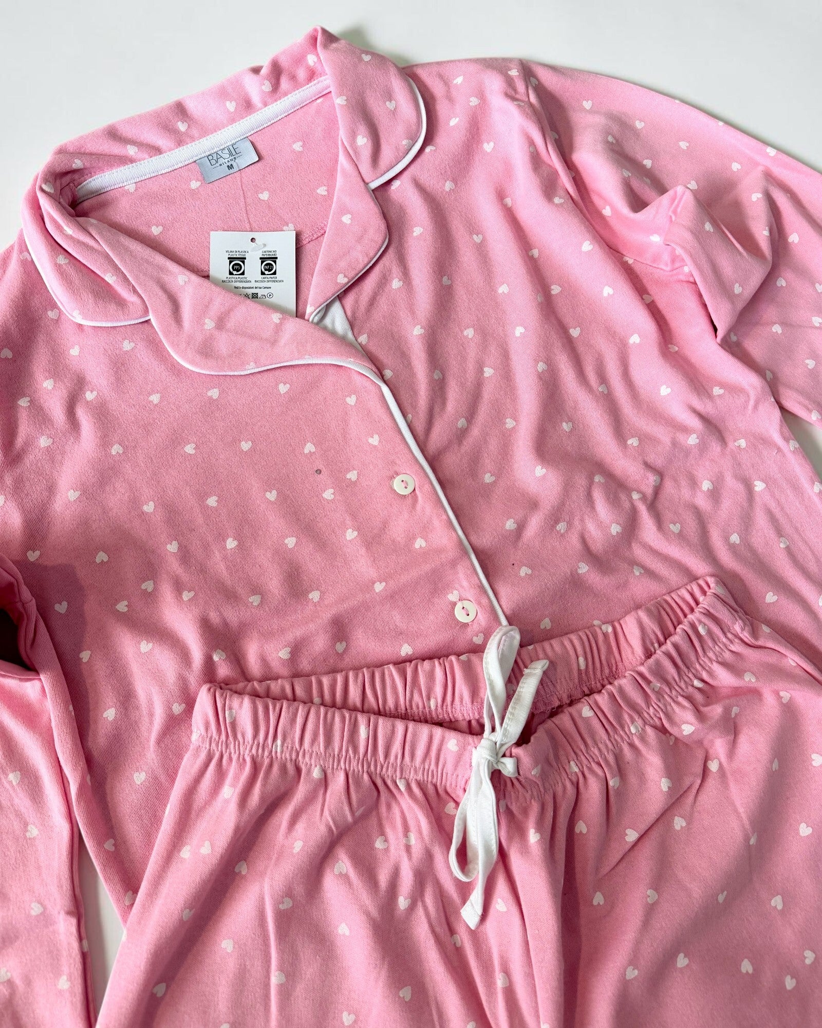 Dettaglio del pigiama donna Basile Milano 4531 rosa con profili bianchi, bottoni e pantaloni con elastico e laccetto in vita.