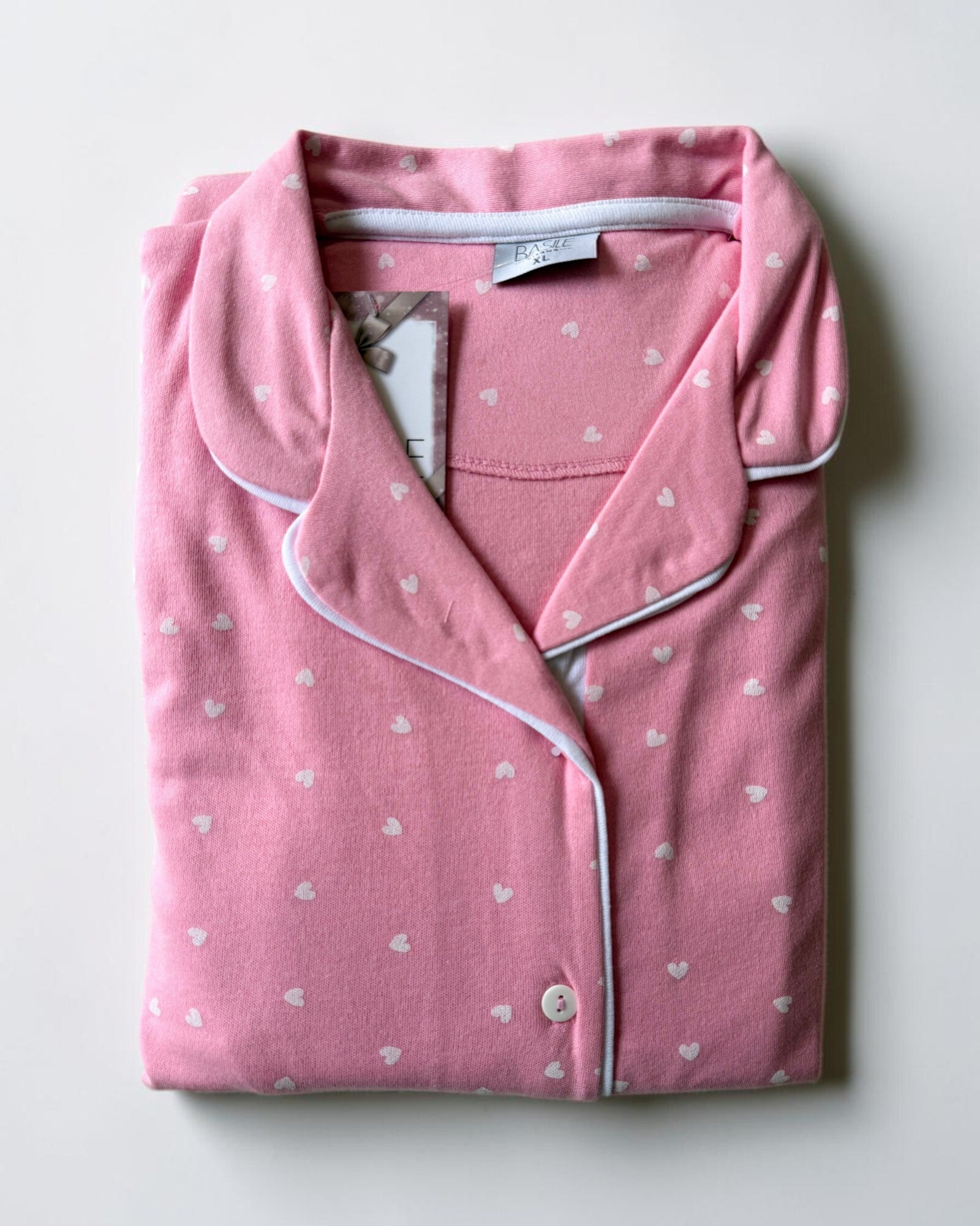 Maglia del pigiama Basile Milano 4531 rosa piegata, con cuoricini bianchi, collo rever e chiusura con bottoni.