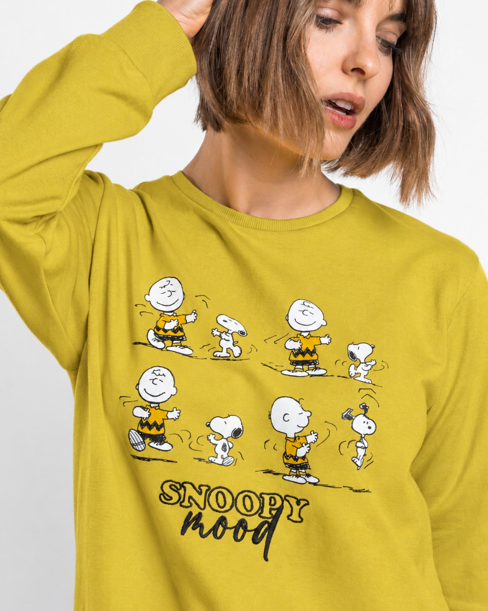 Dettaglio della maglia gialla con Snoopy, Charlie Brown e scritta Snoopy Mood con dettagli ricamati