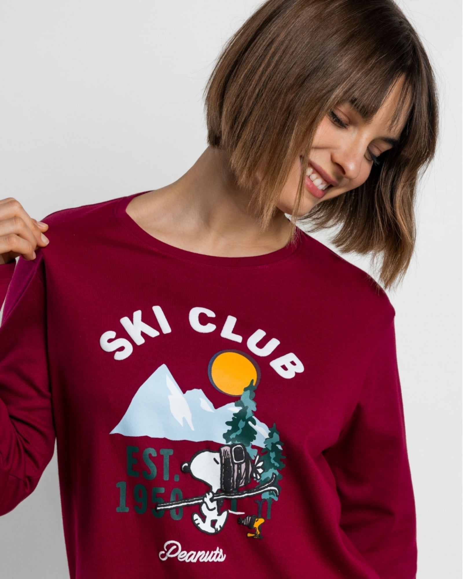 Dettaglio della maglia ciliegia con scritta Ski Club, Snoopy, Woodstock e montagne innevate