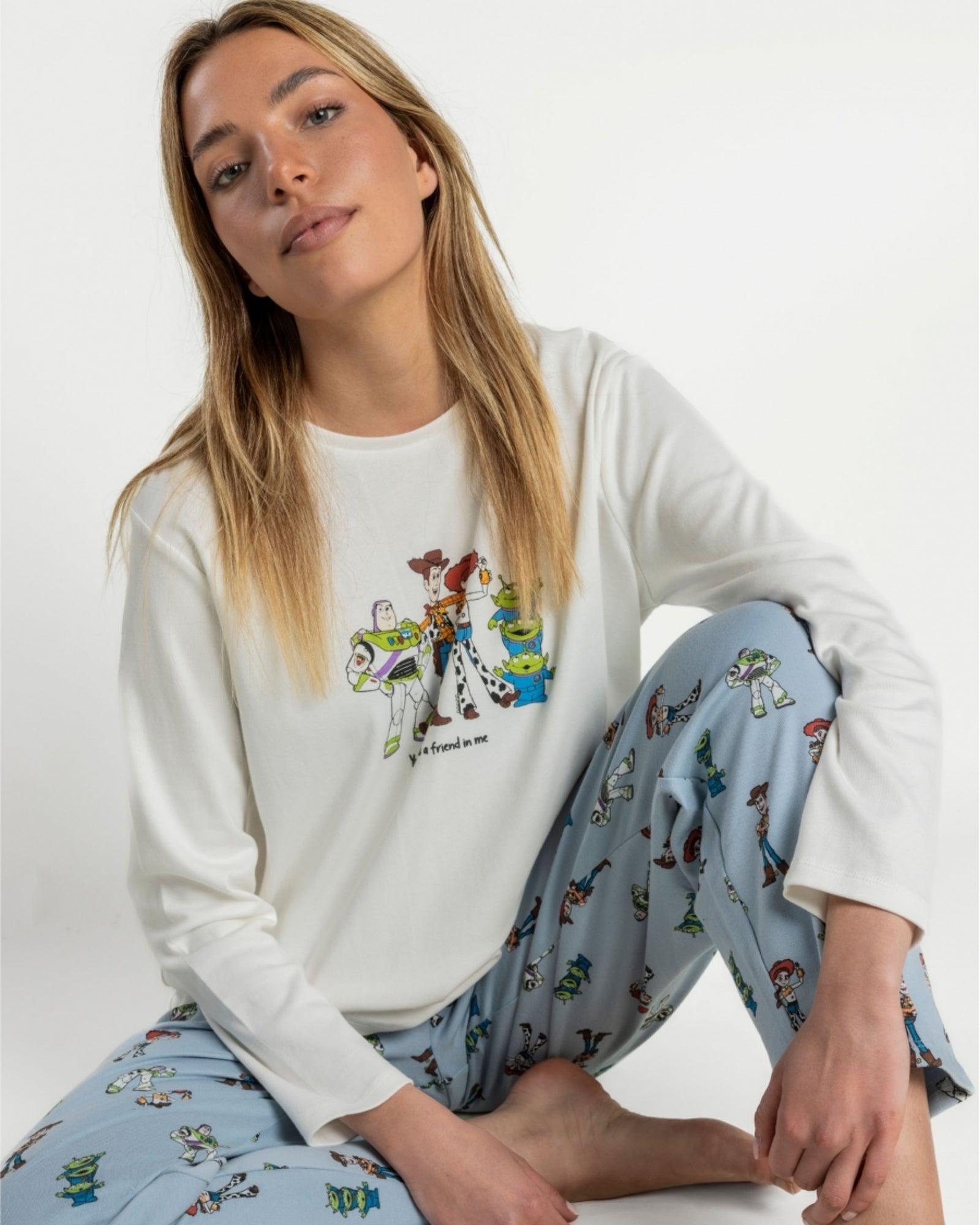 Pigiama Toy Story 64677 indossato da una modella seduta, con stampa dei personaggi sulla maglia e sui pantaloni azzurri