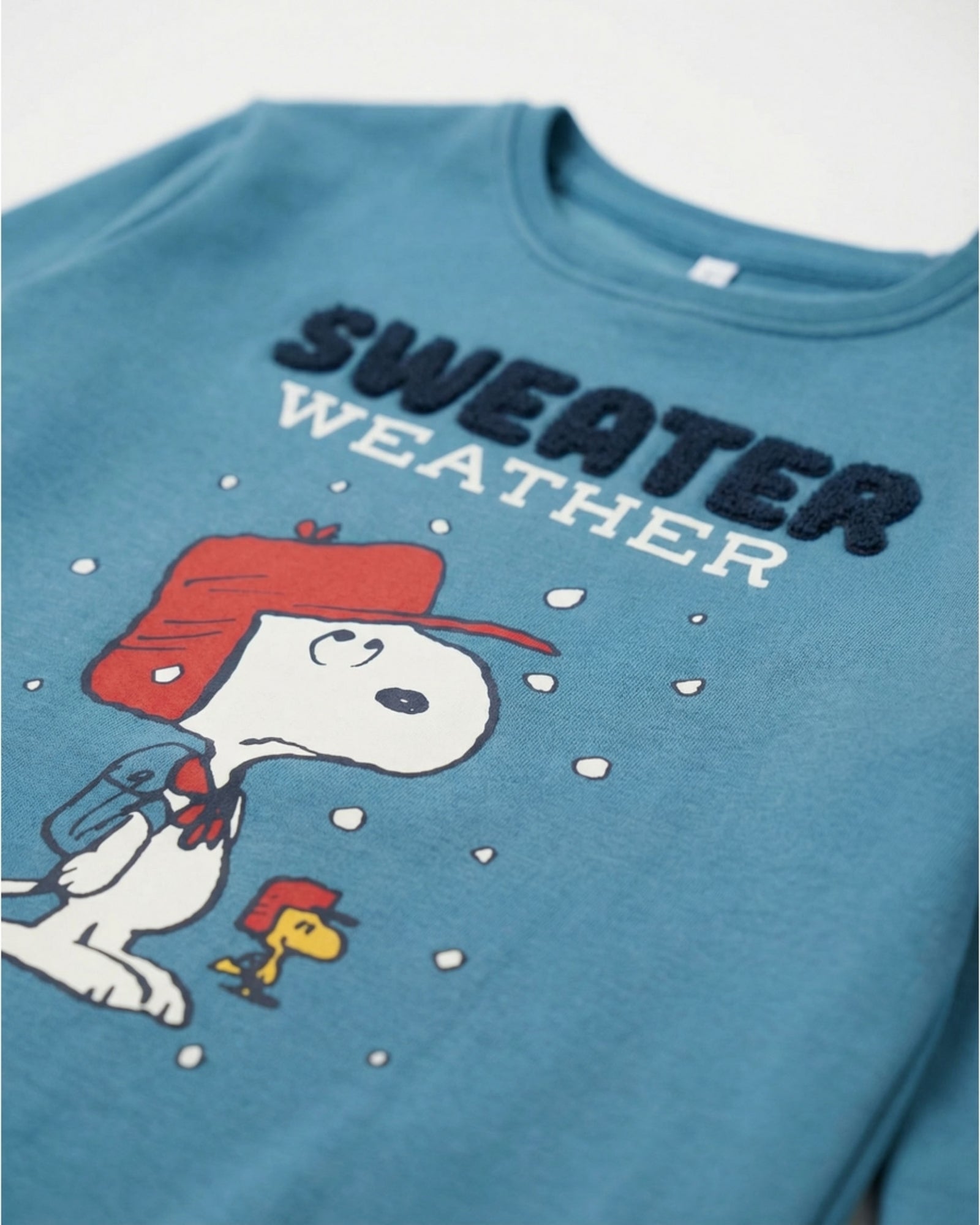 Dettaglio maglia pigiama bambino Peanuts Snoopy Sweater Weather color Oceano con ricamo in spugna
