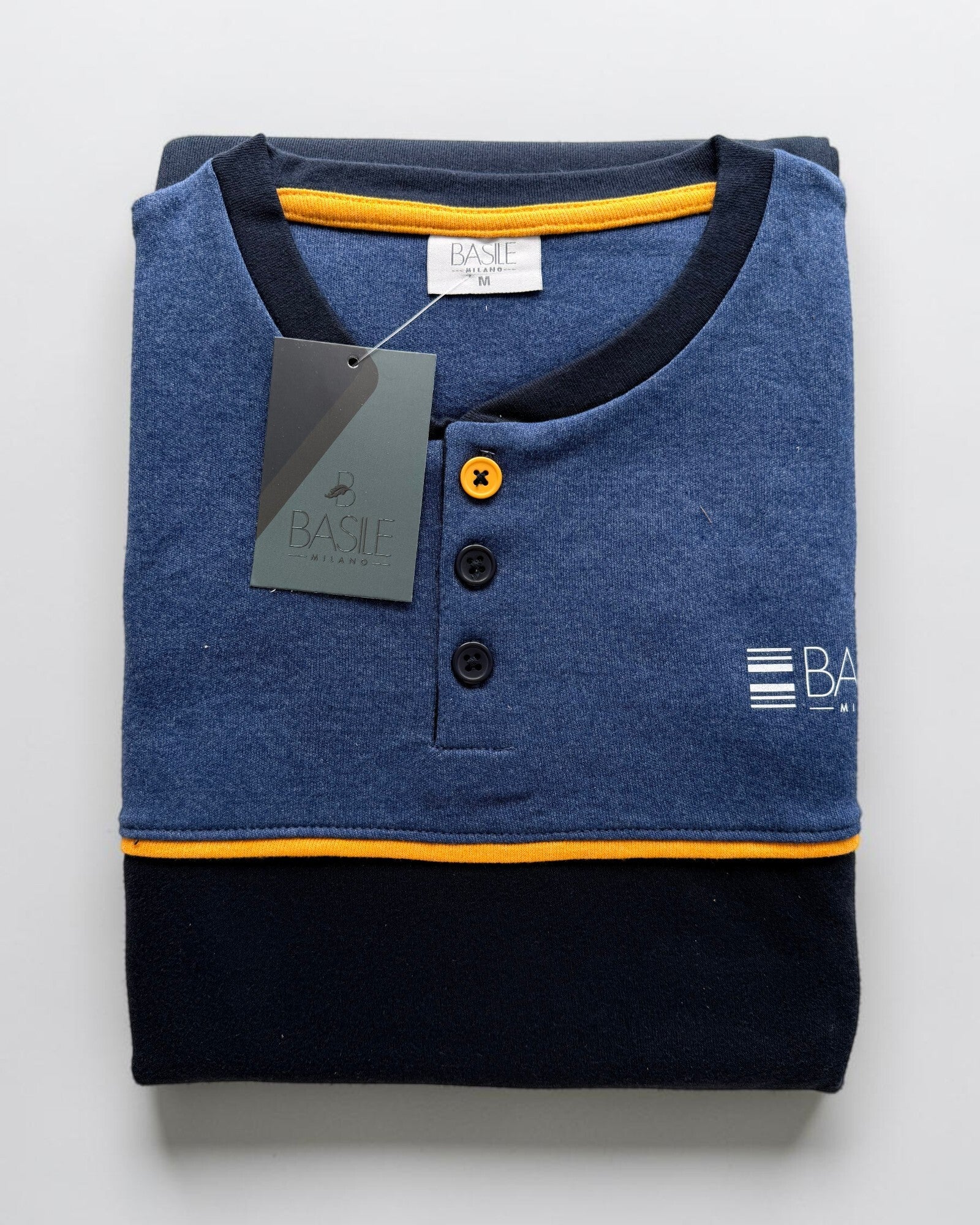 Pigiama Basile Milano blu piegato, con tre bottoni sullo scollo serafino e dettagli gialli a contrasto