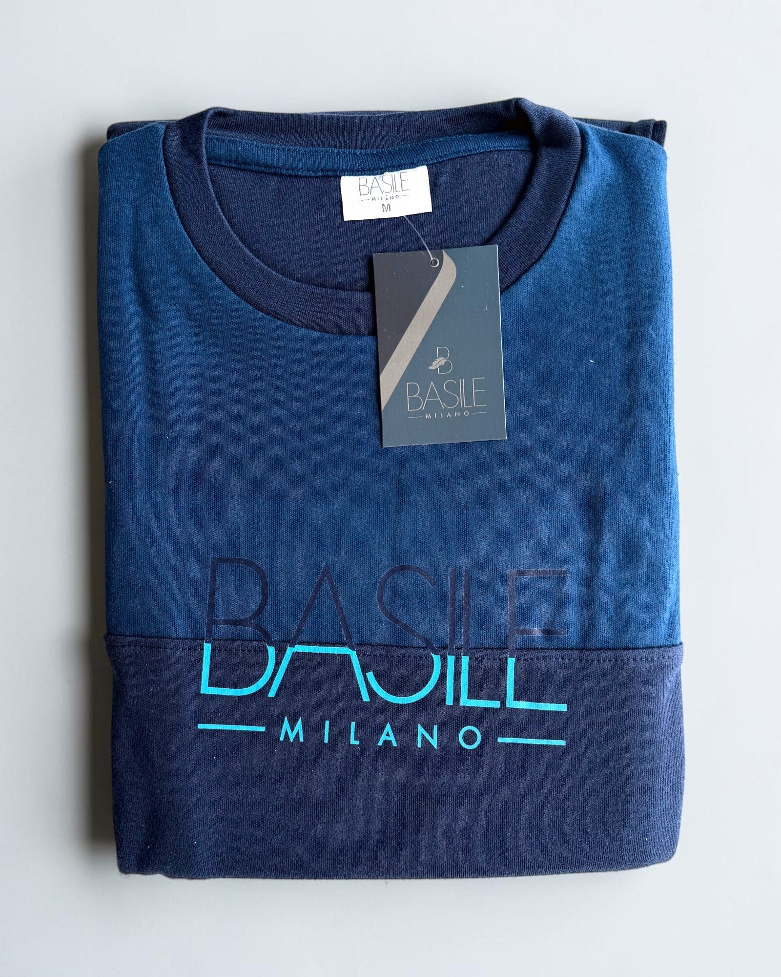 Maglia piegata del pigiama Basile Milano 4030 ottanio, con girocollo blu scuro e stampa centrale a contrasto