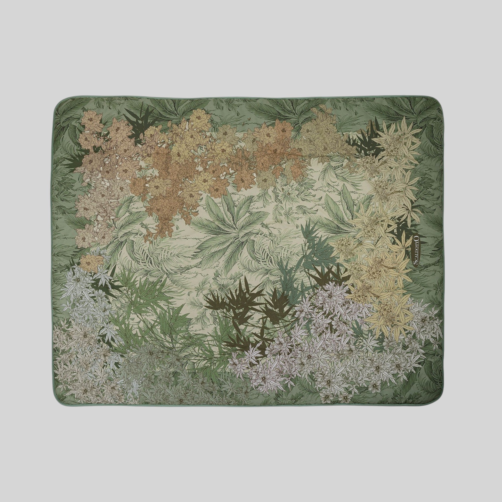 Plaid Caleffi Oasi Green disteso con fantasia di foglie e fiori
