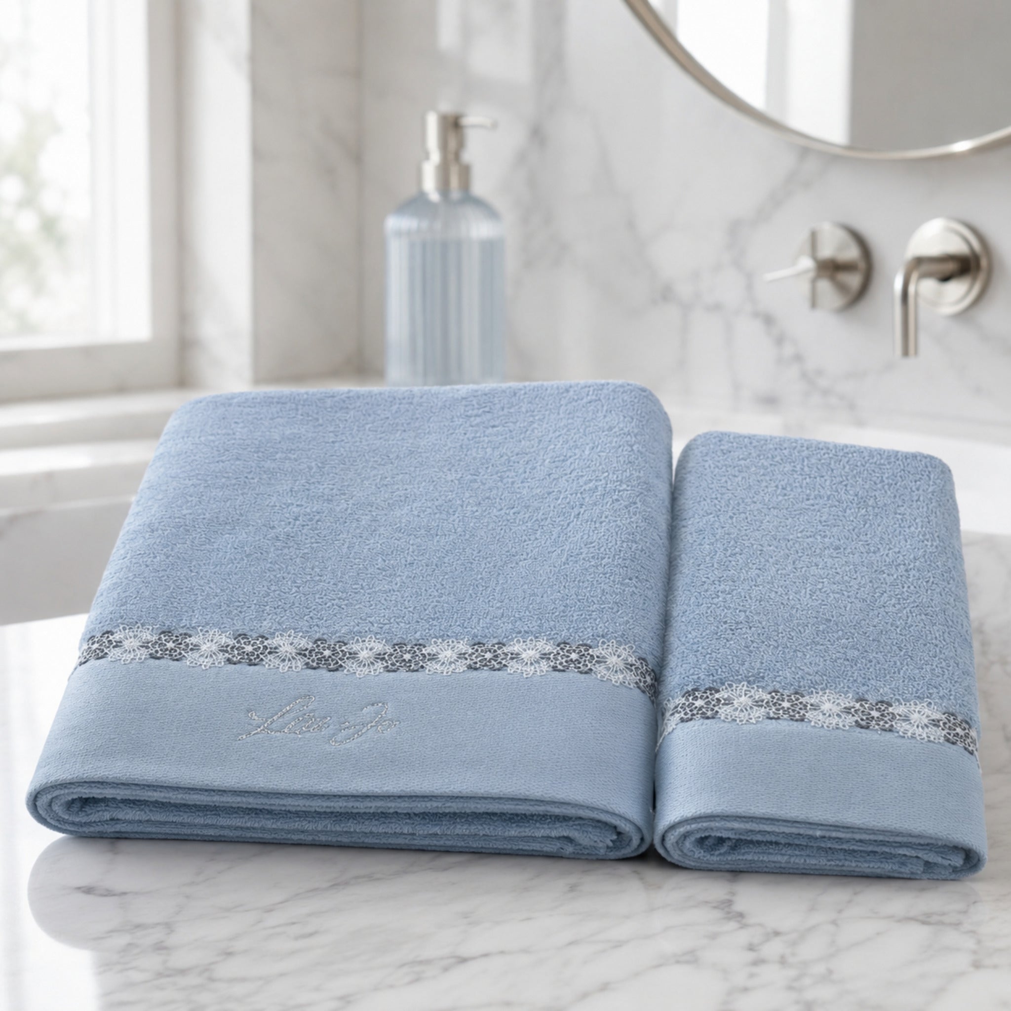 Set asciugamani 1+1 Liu Jo Everest colore Zucchero con telo viso e ospite ambientati in un bagno elegante