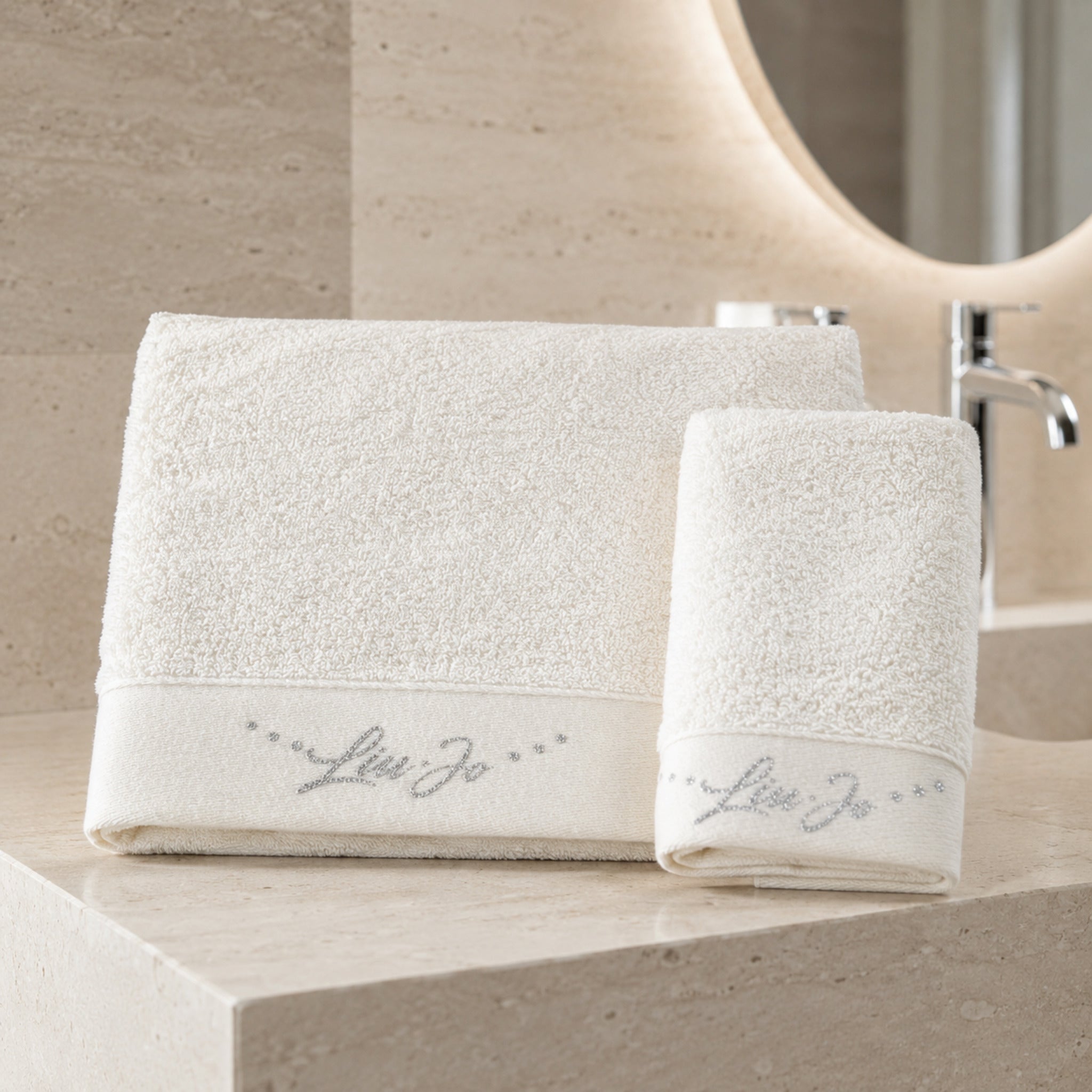 Set asciugamani 1+1 Liu Jo Happy colore avorio con telo viso e ospite ambientati in un bagno elegante