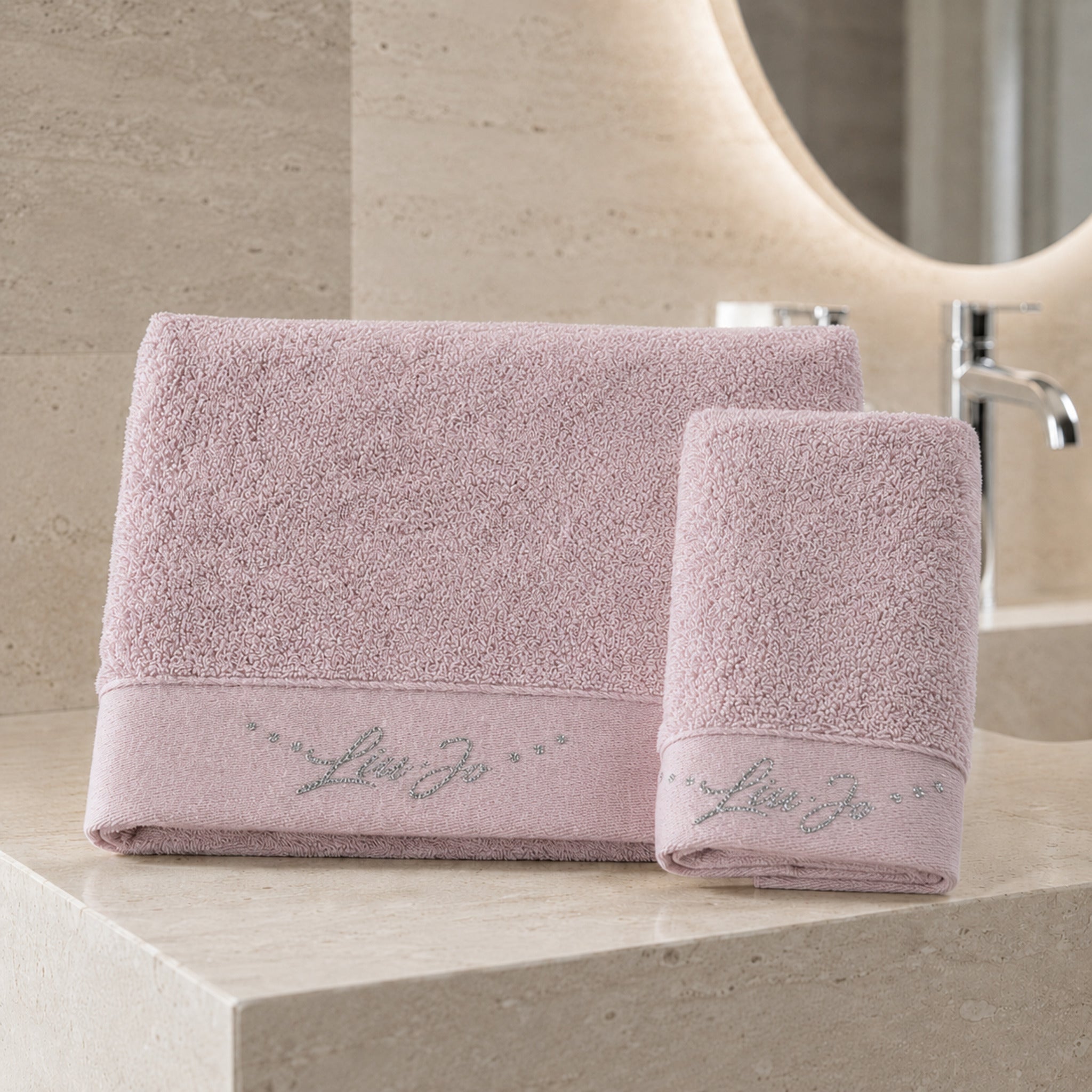 Set asciugamani 1+1 Liu Jo Happy colore rosa con telo viso e ospite ambientati in un bagno elegante