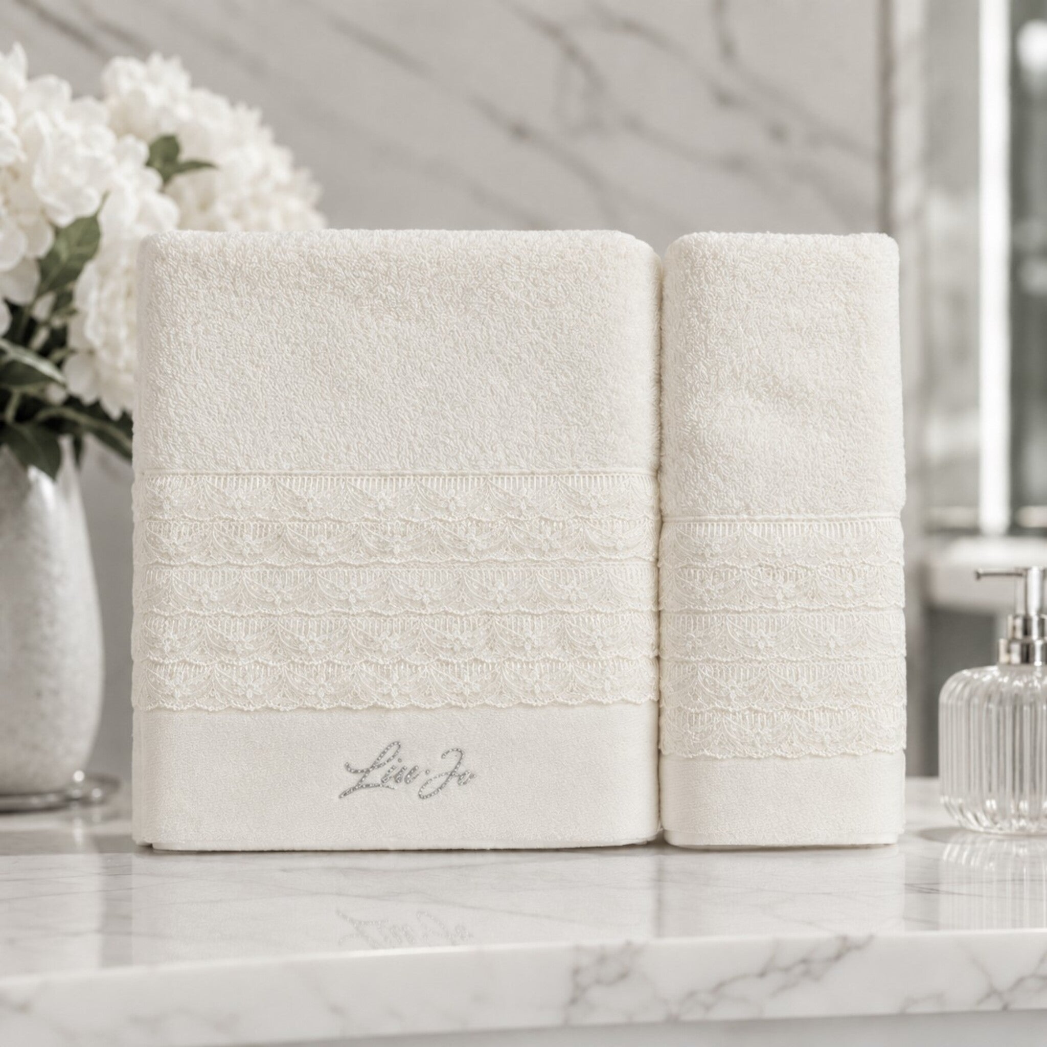 Set asciugamani 1+1 Liu Jo Paradiso Avorio con telo viso e ospite ambientati in un bagno elegante