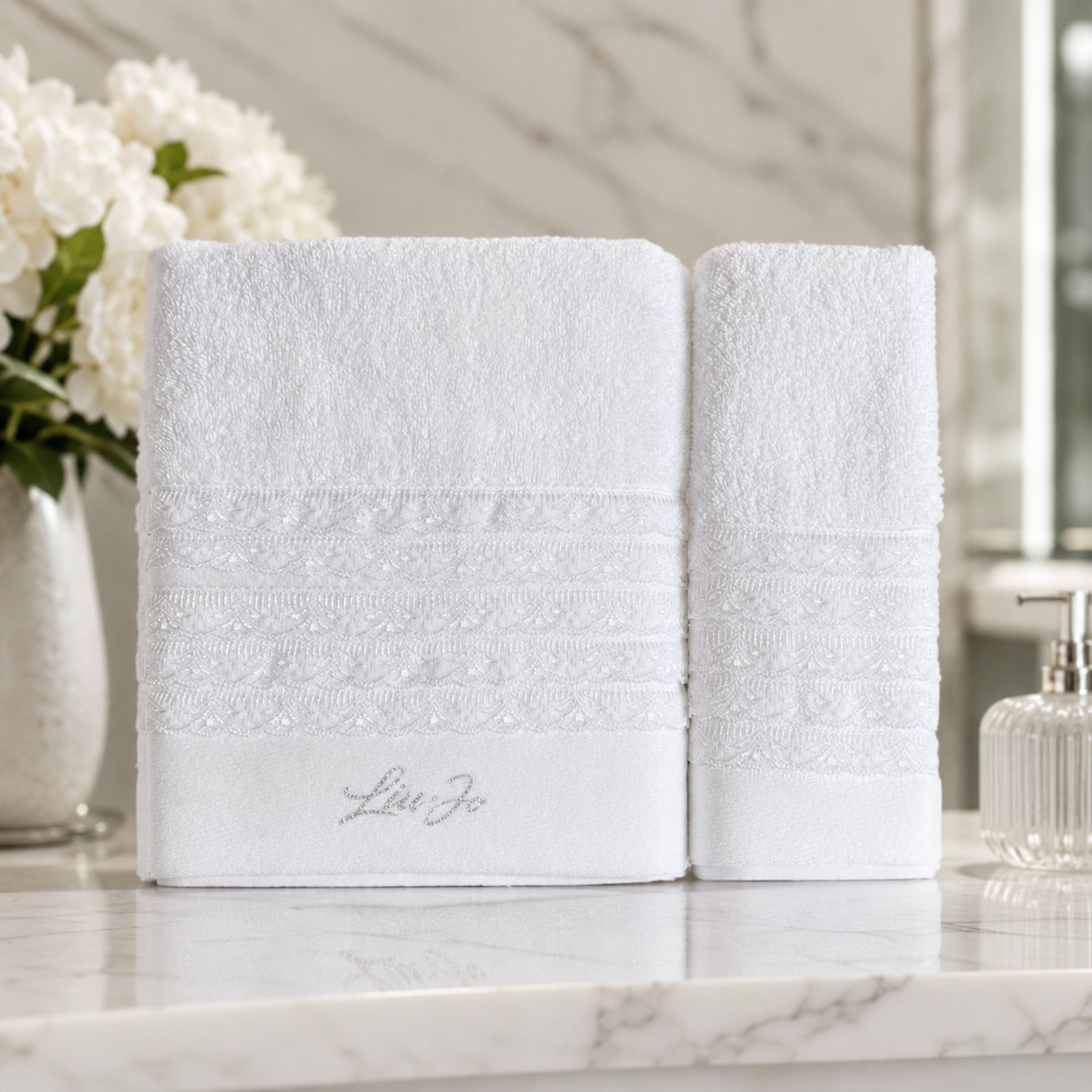 Set asciugamani 1+1 Liu Jo Paradiso Bianco con telo viso e ospite ambientati in un bagno elegante