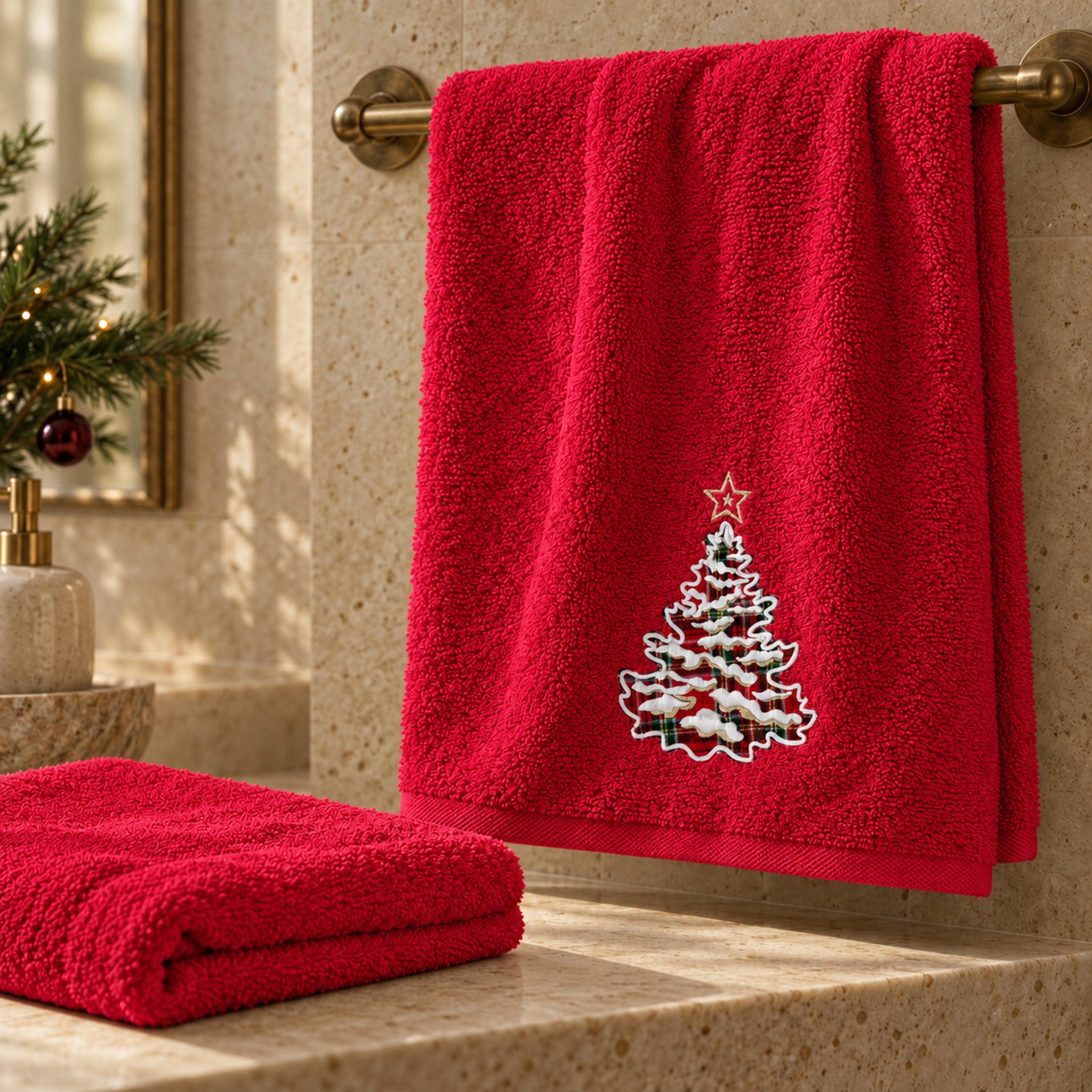 Set Plume Snowtree Rosso ambientato in bagno, con albero tartan sull’asciugamano viso e ospite unito ripiegato.