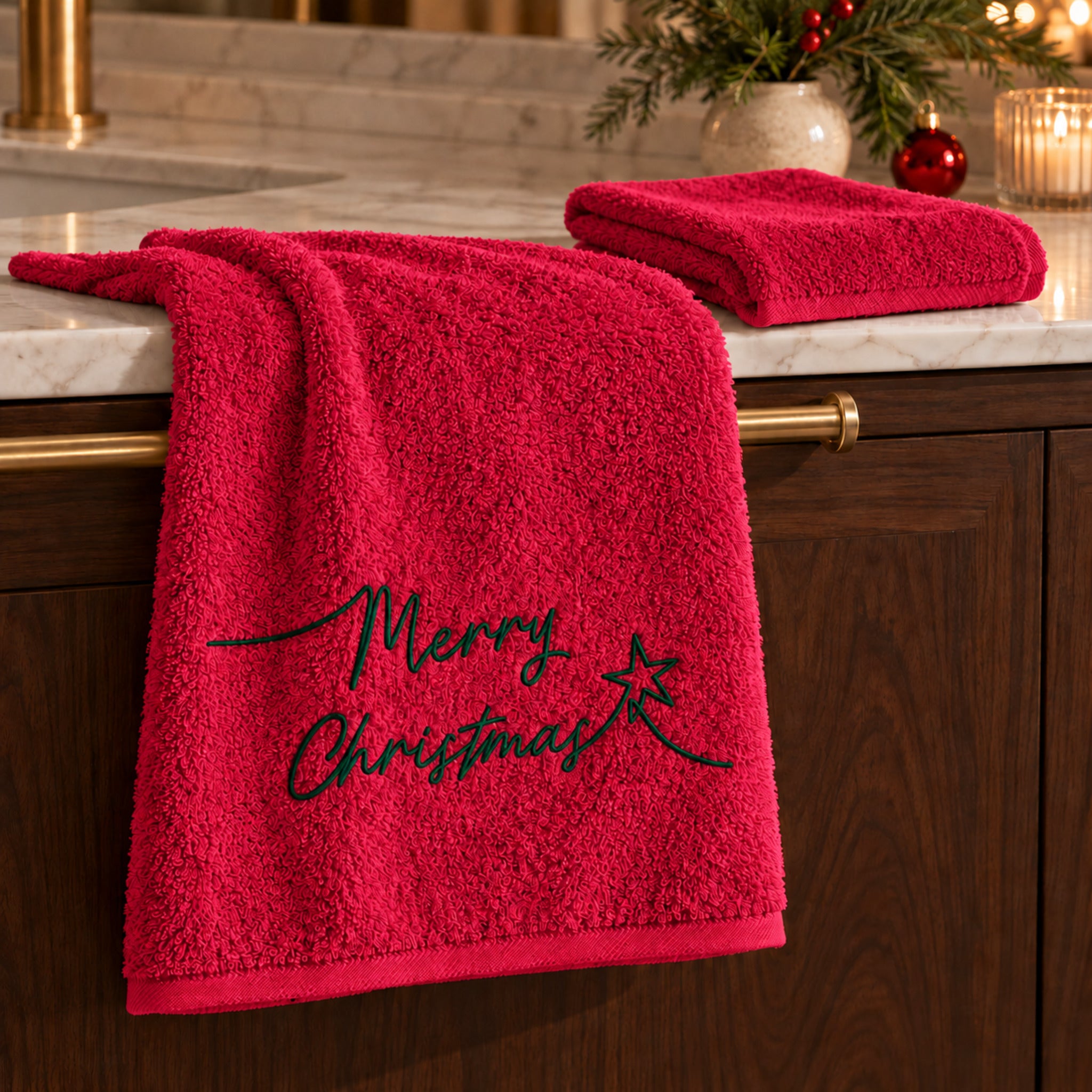 Set Plume Starlight Rosso ambientato in bagno, con ricamo Merry Christmas verde sul viso e ospite unito.