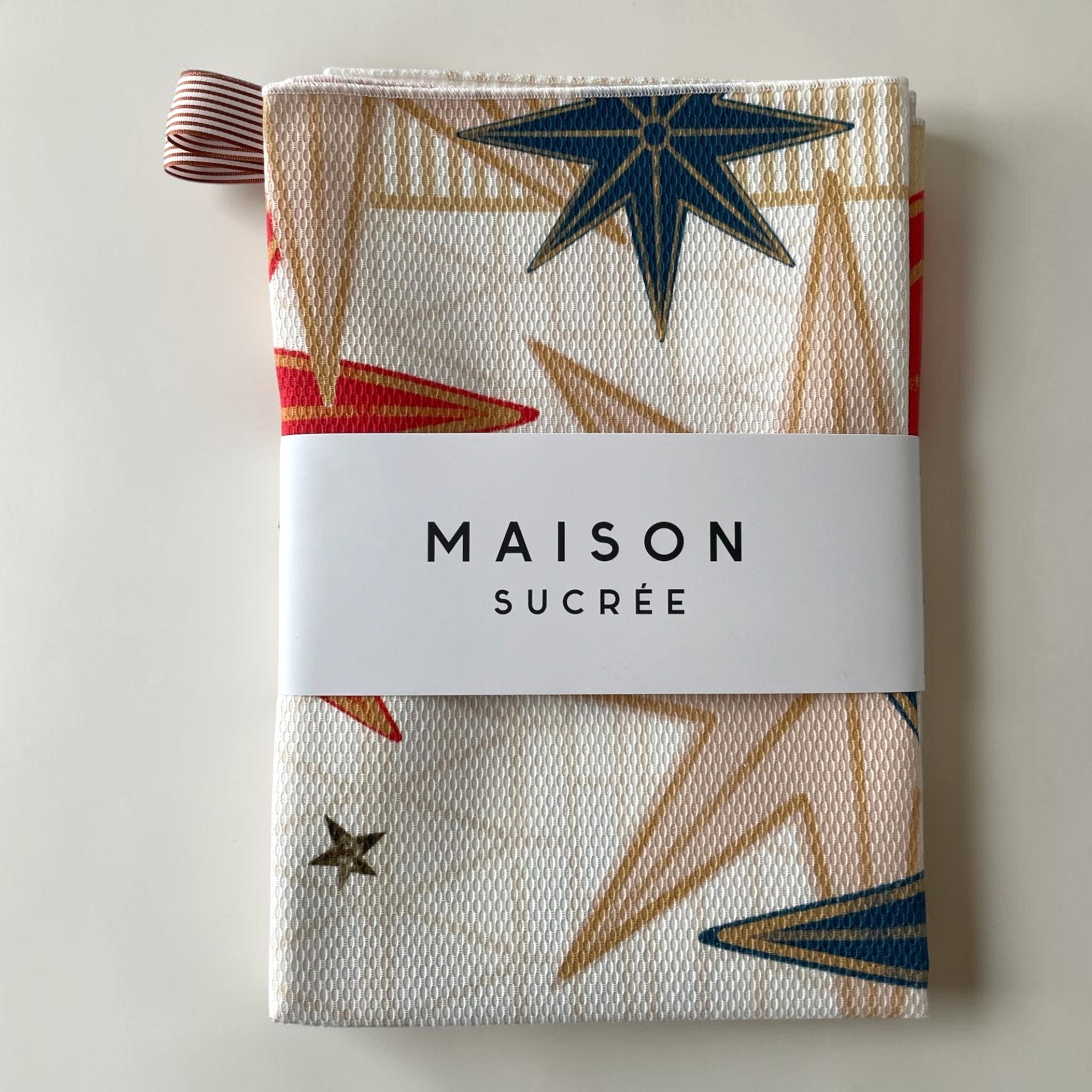 Confezione di strofinacci Maison Sucrée Incanti fantasia stelle multicolor, con fascetta del marchio e gancio in tessuto.
