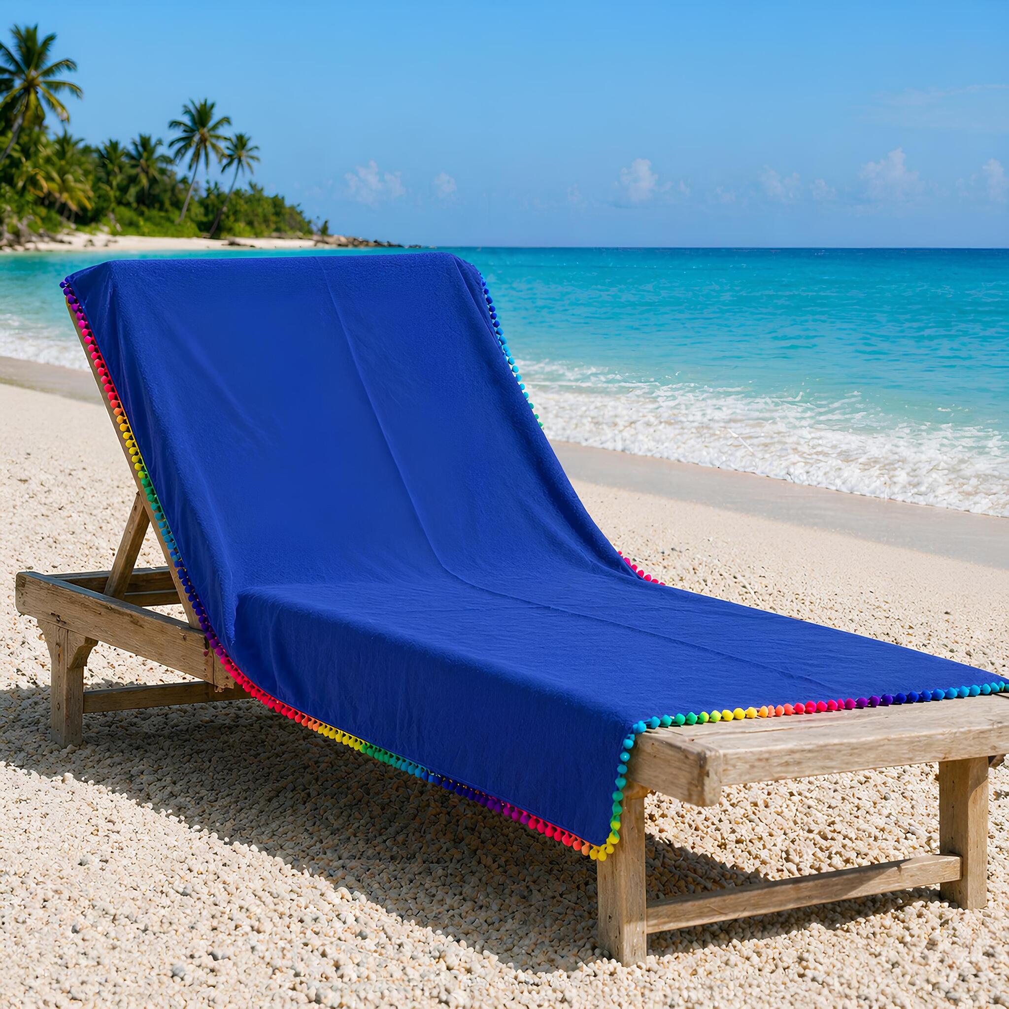 telo mare microfibra blu con pon pon colorati su lettino spiaggia