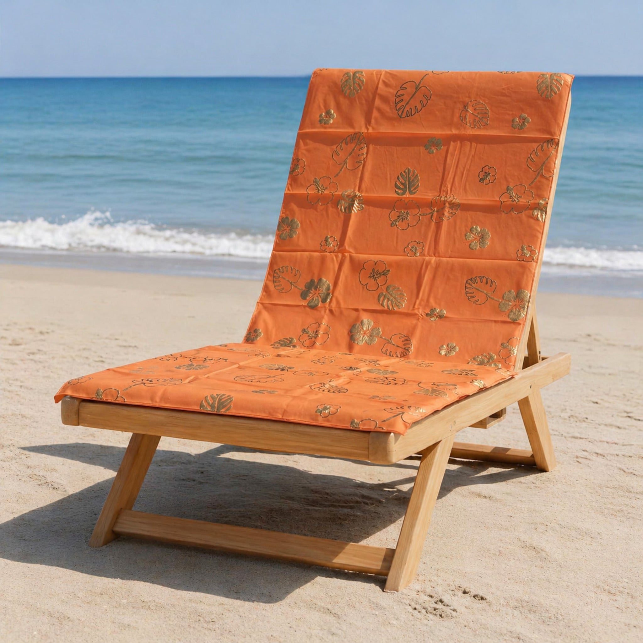 telo mare microfibra arancio con stampa foglie e fiori tropicali su lettino spiaggia