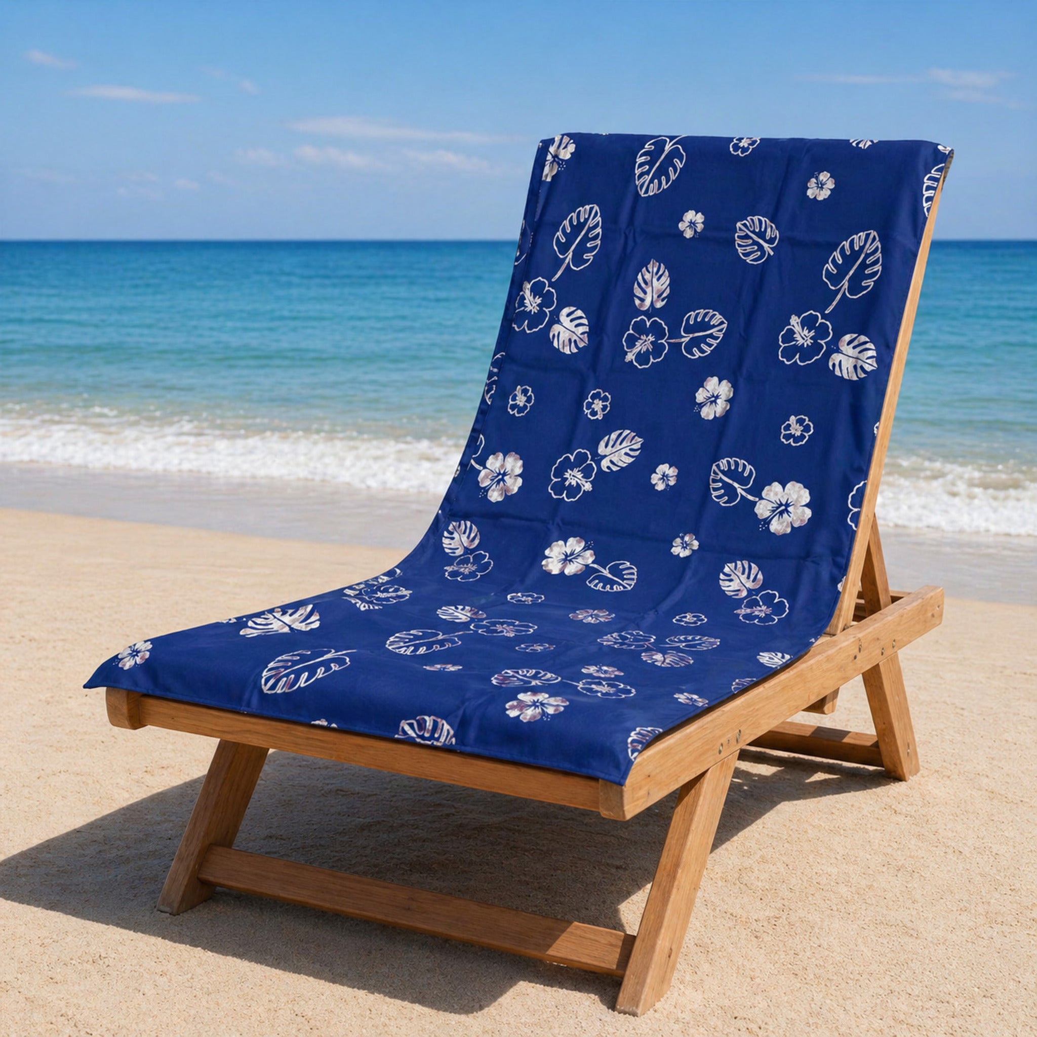 telo mare microfibra blu con stampa foglie e fiori tropicali su lettino spiaggia