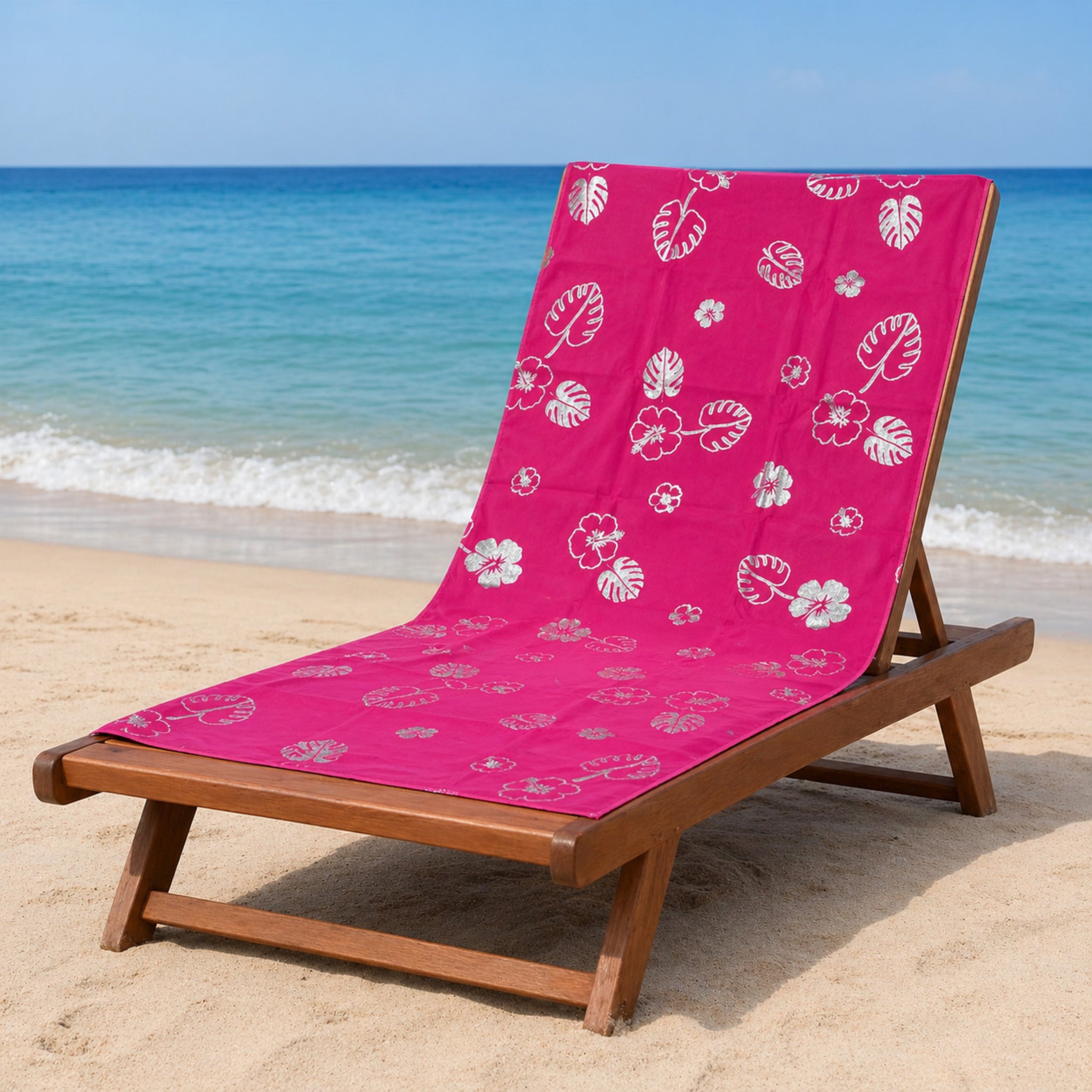 telo mare microfibra fucsia con stampa foglie e fiori tropicali su lettino spiaggia