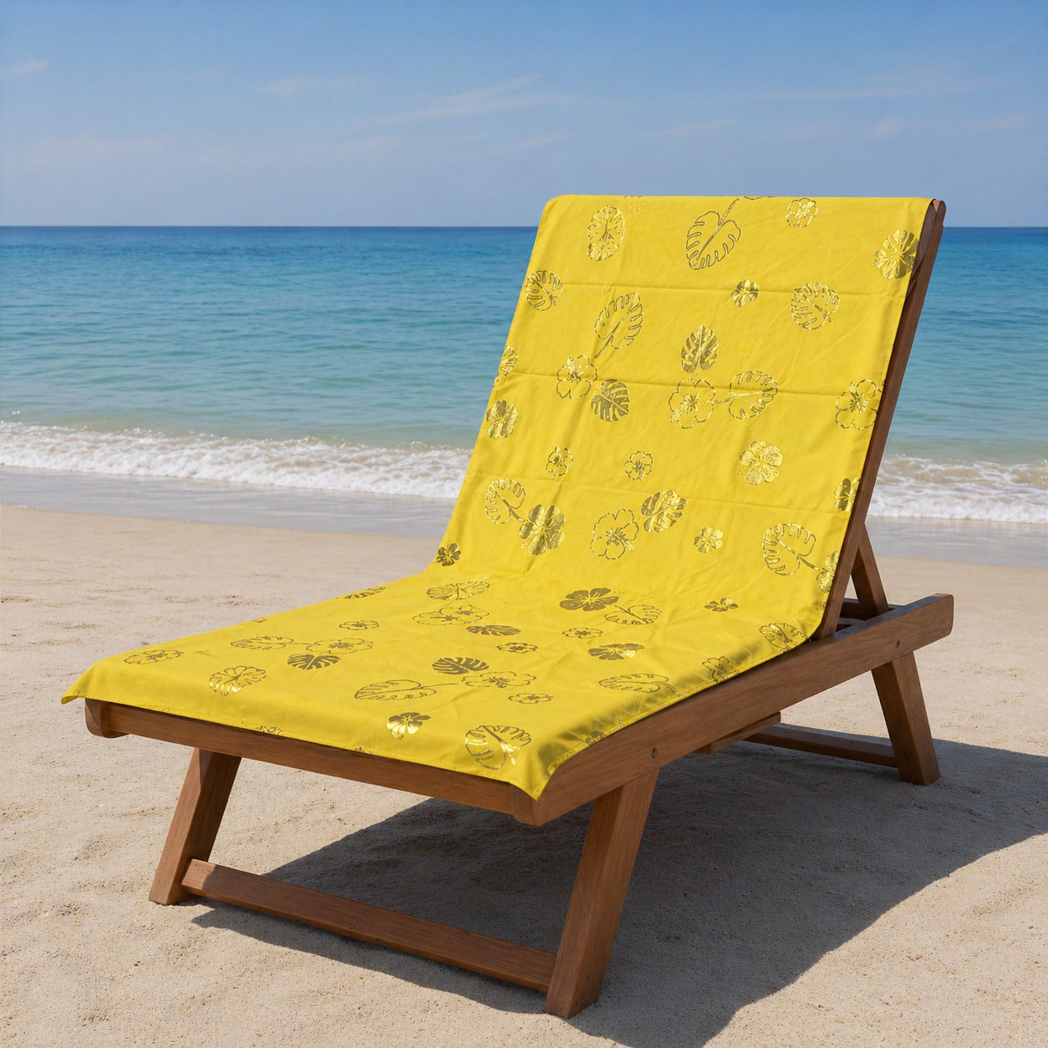 telo mare microfibra giallo con stampa foglie e fiori tropicali su lettino spiaggia
