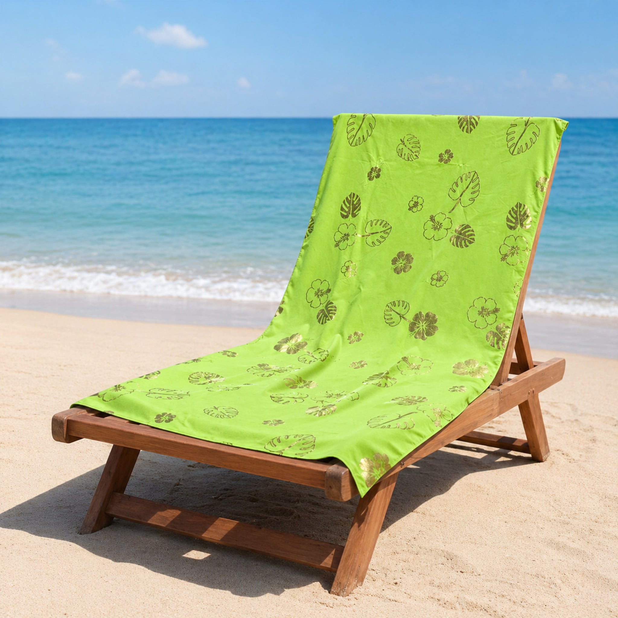 telo mare microfibra verde con stampa foglie e fiori tropicali su lettino spiaggia