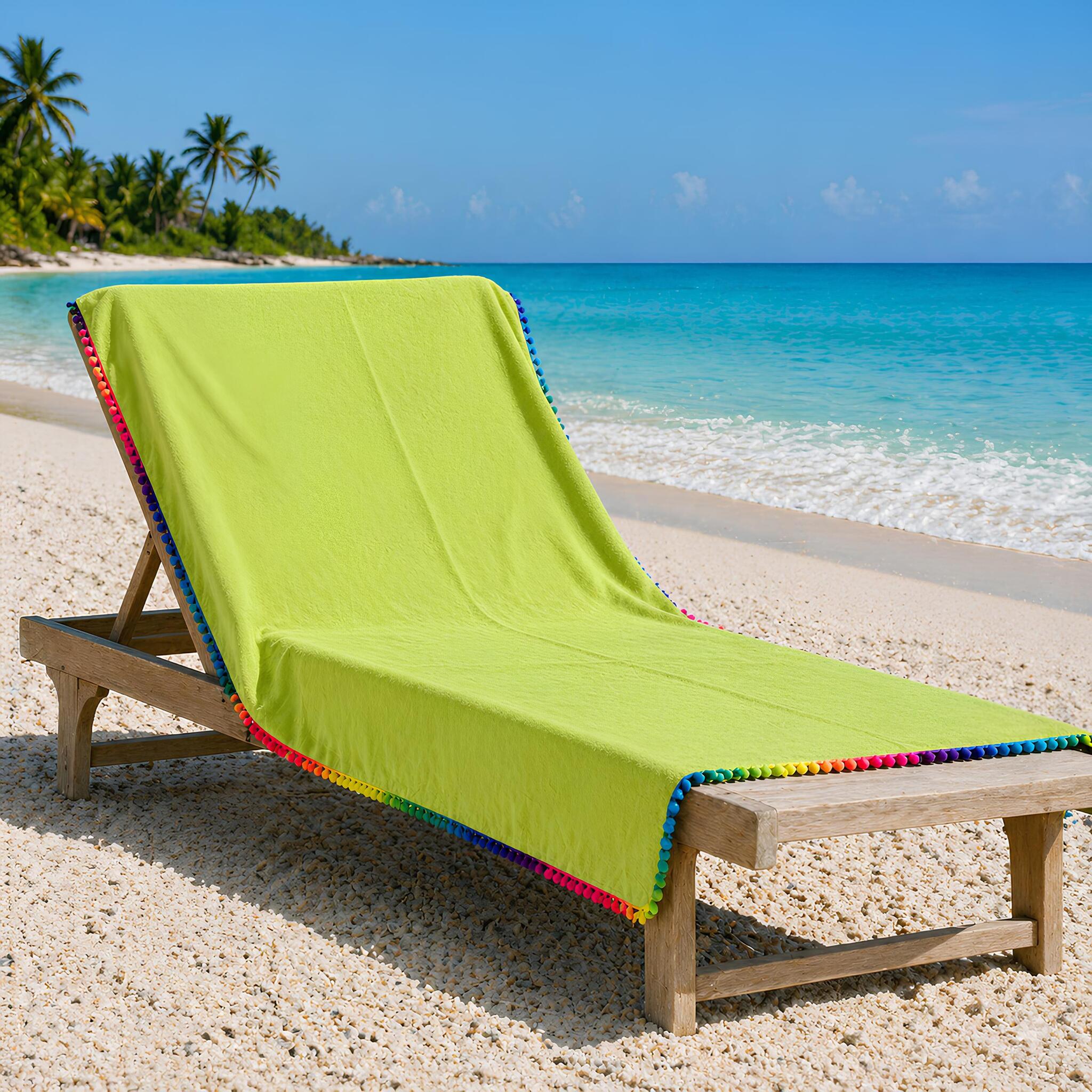 telo mare microfibra verde con pon pon colorati su lettino spiaggia