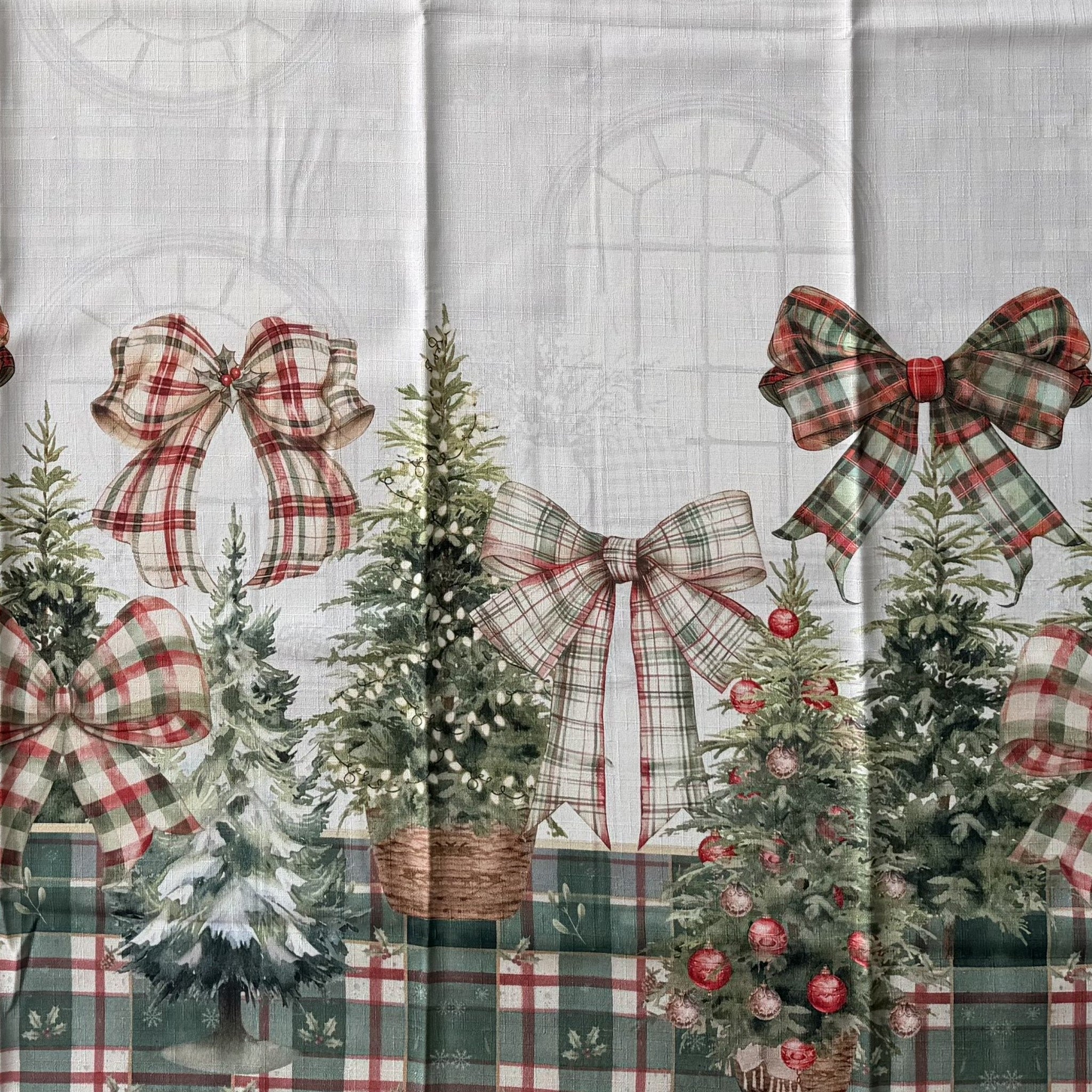 Dettaglio della fantasia Natale in salotto con abeti in cesti, alberi innevati, grandi fiocchi e bordo tartan rosso e verde.