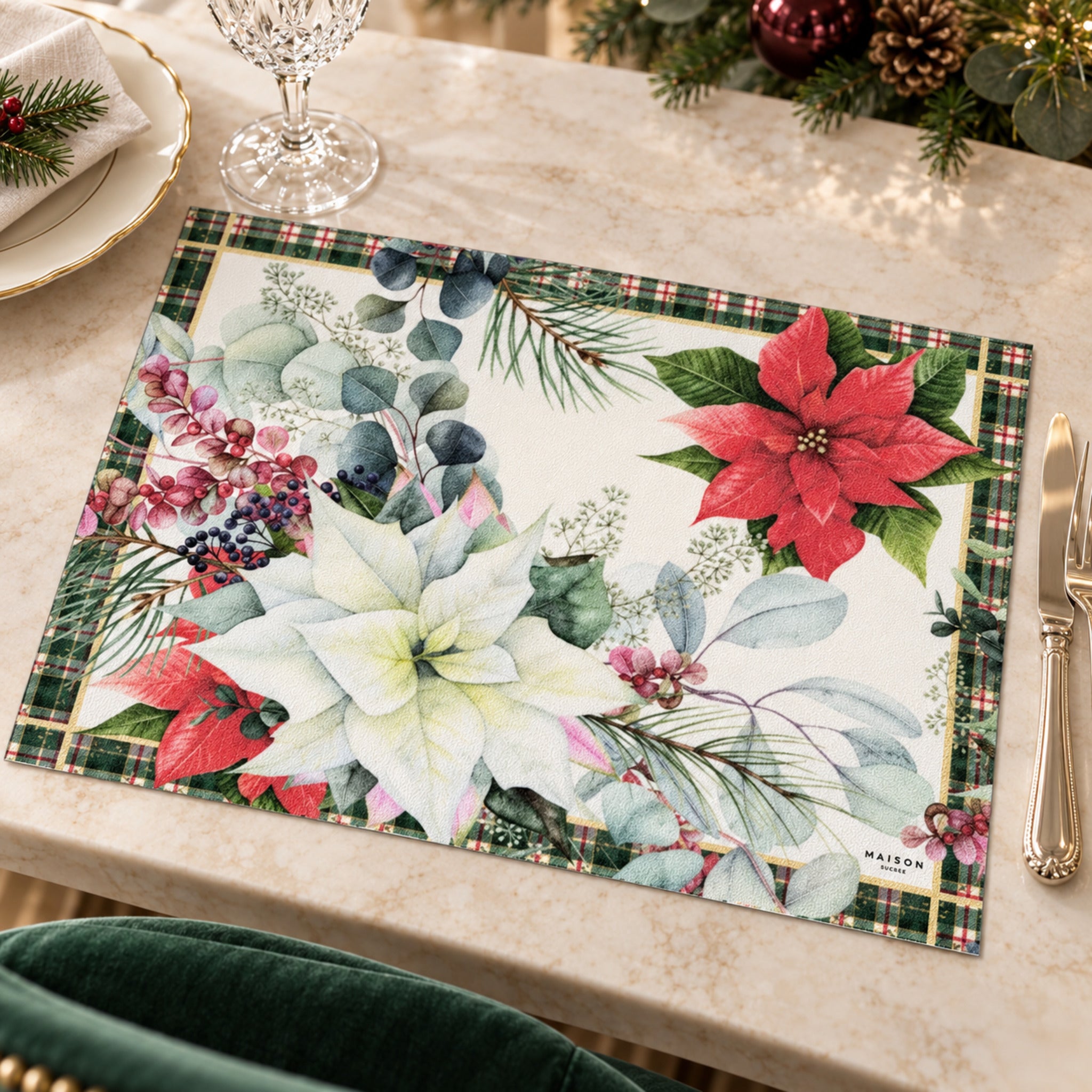 Tovaglietta natalizia Maison Sucrée con stelle di Natale rosse e avorio, foglie e bordo tartan su tavola apparecchiata.